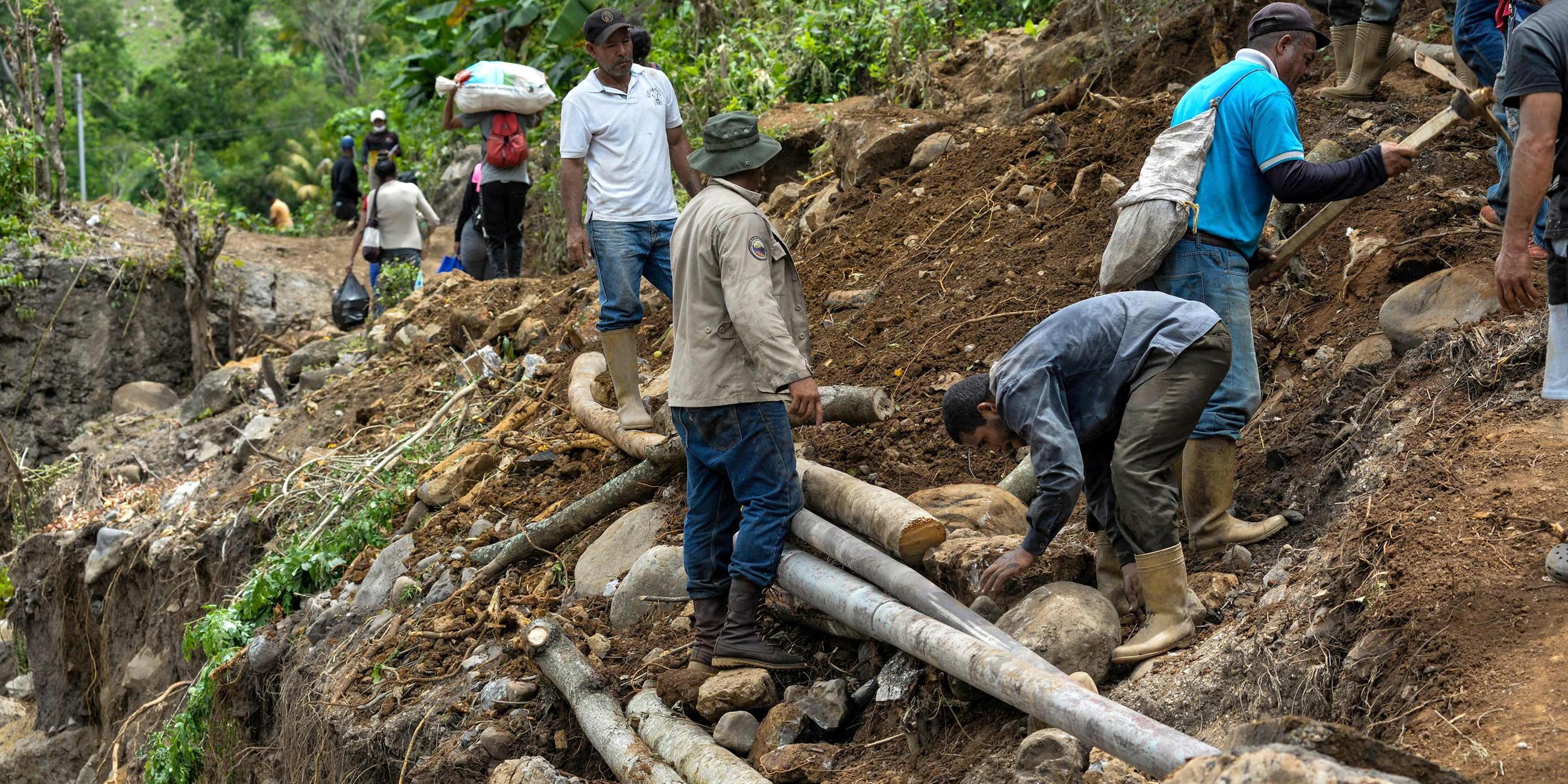 Menschen in Venezuela arbeiten am Wiederaufbau einer Straße.