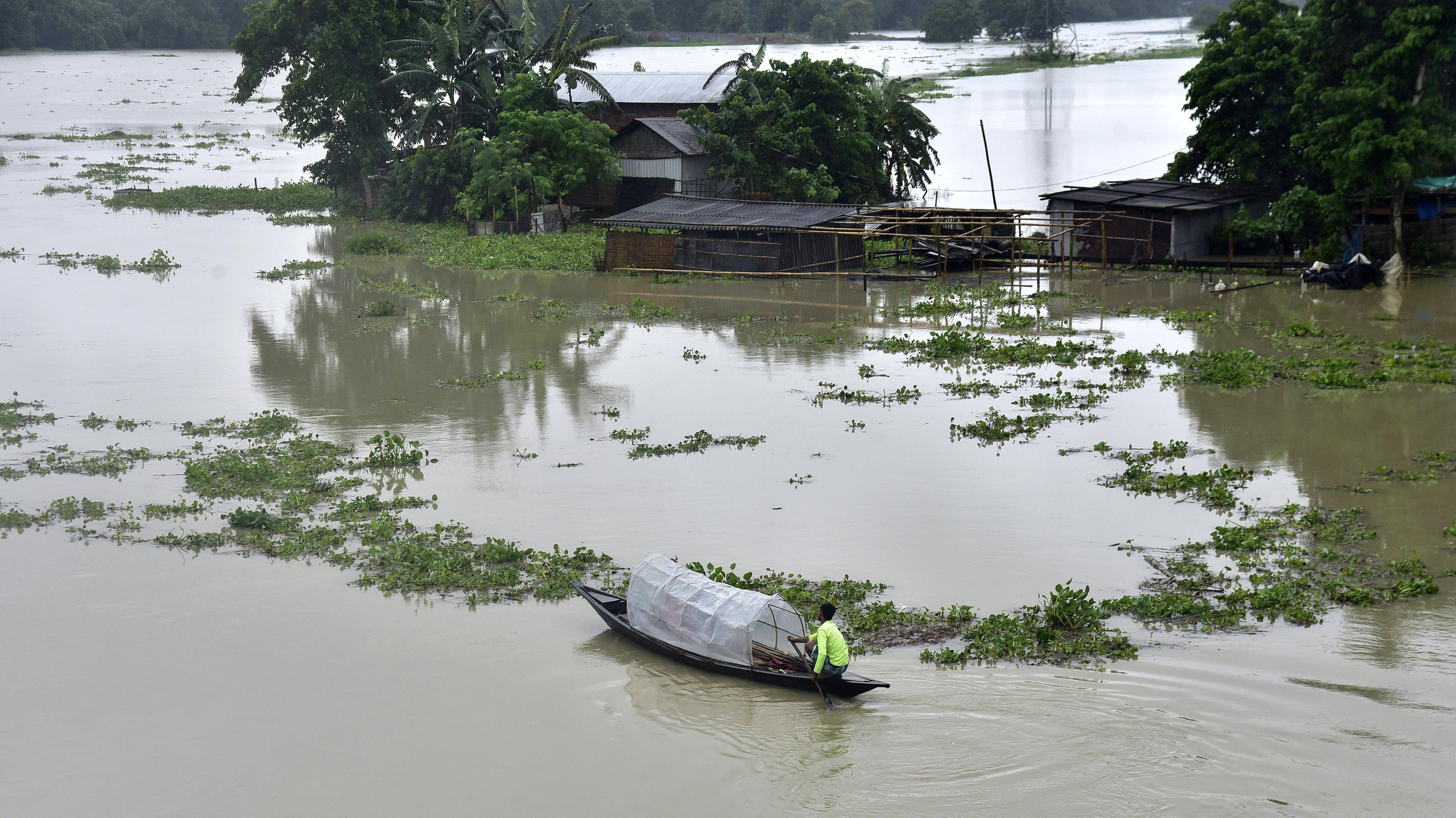 Ein Boot fährt in der Nähe überfluteter Häuser im Distrikt Morigaon in Assam, Indien, am 2. Juli 2024 vorbei.