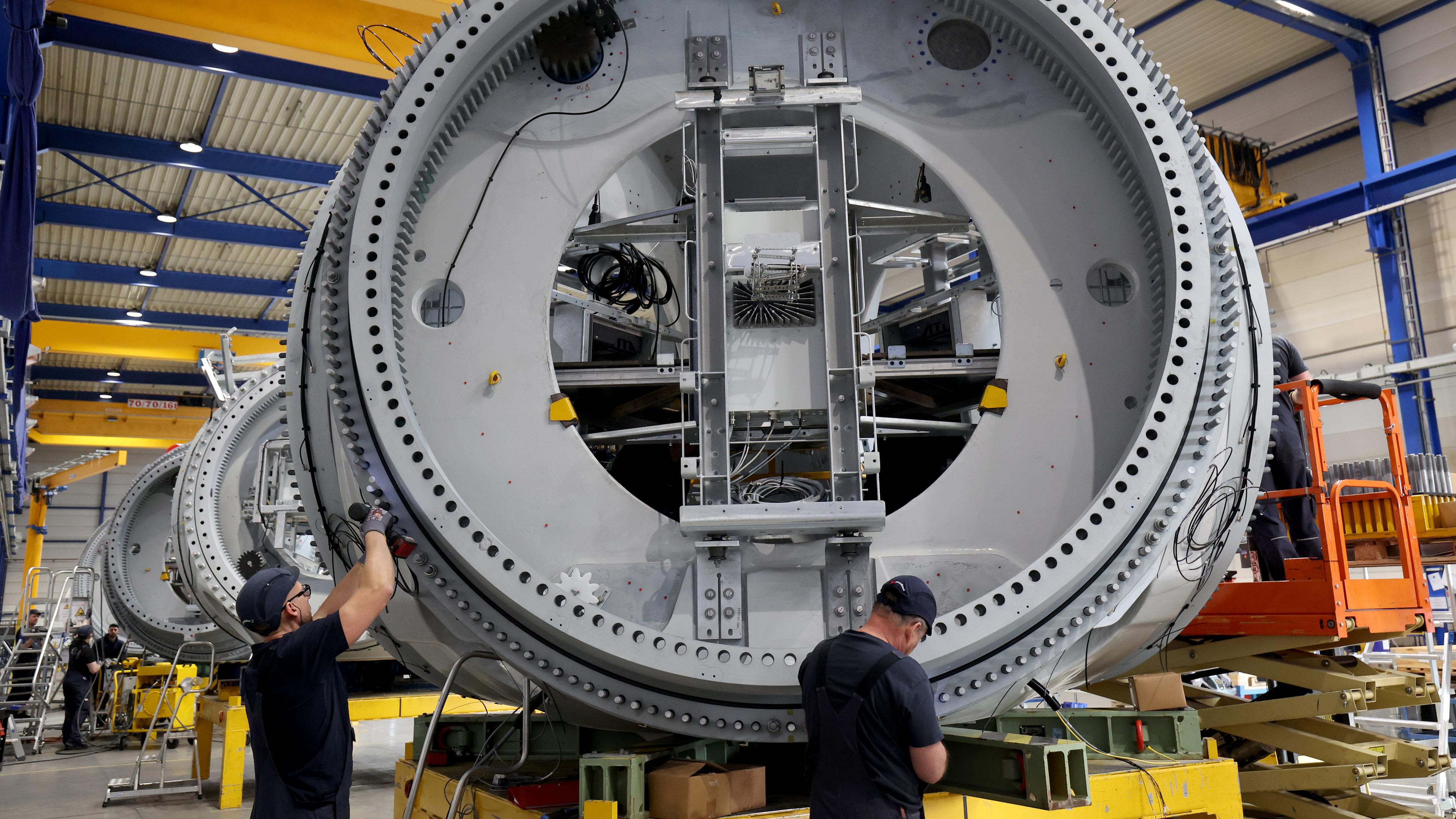 Symbolbild: Bei einem Anlagenbauer arbeiten Mitarbeiter an einer Nabe für die Turbine einer Windkraftanlage. 