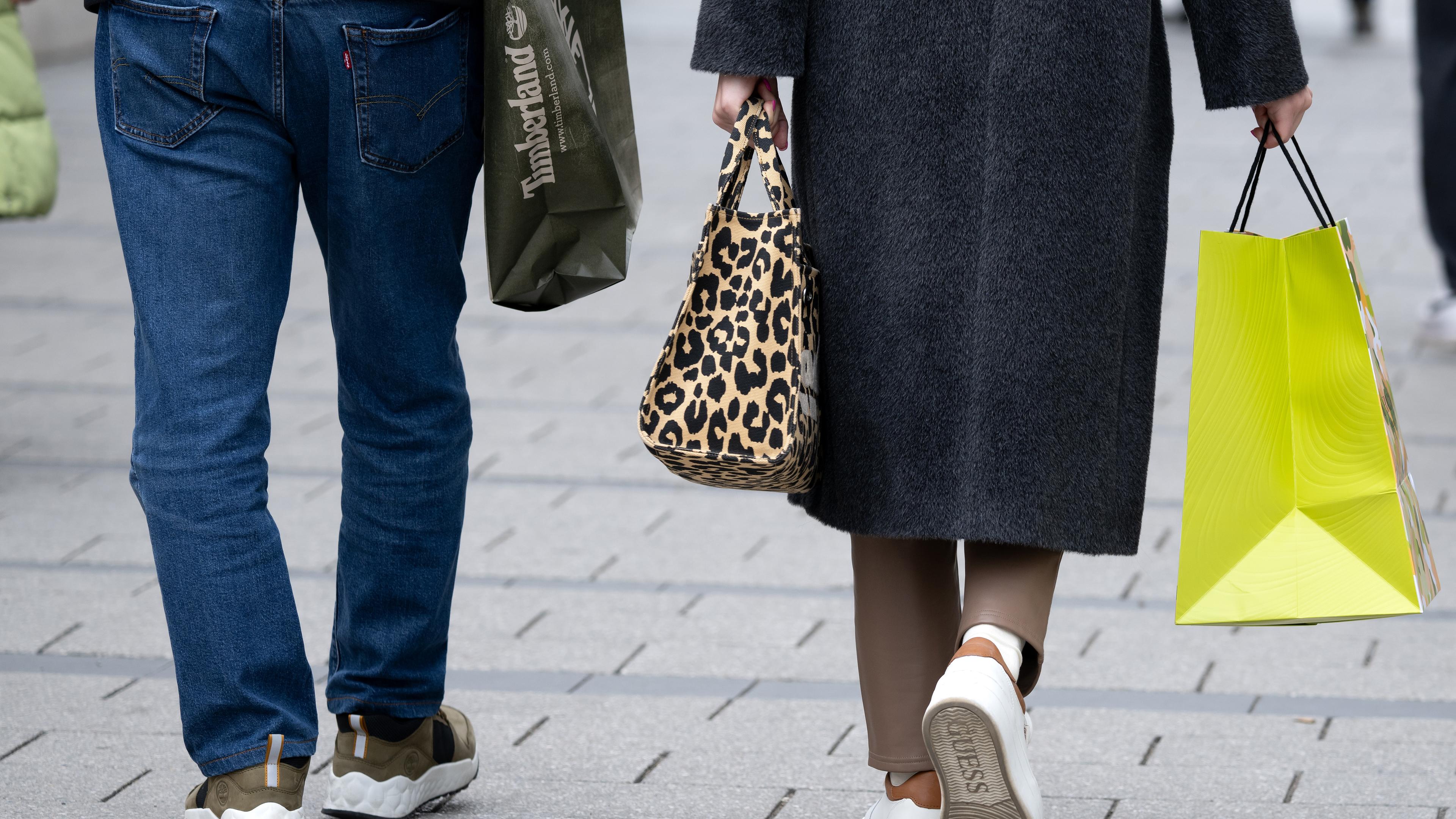 Ein Mann und eine Frau gehen in der Innenstadt mit Einkaufstüten durch die Fußgängerzone, aufgenommen am 27.02.2024 in München