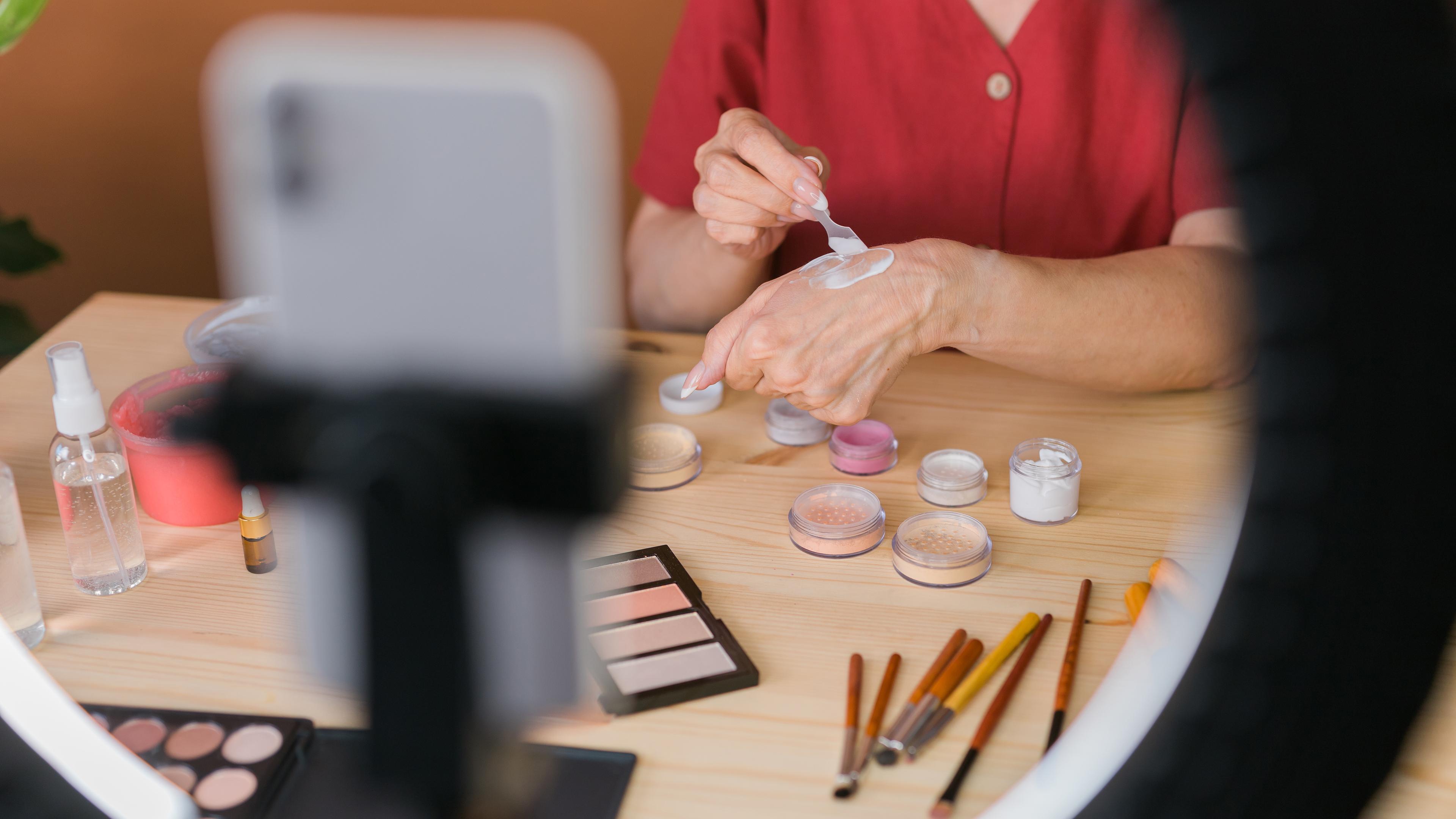 Beauty-Bloggerin oder Influencerin mittleren Alters mit Make-up-Produkt bei der Videoaufnahme in einem Zimmer zu Hause, 02.12.2022