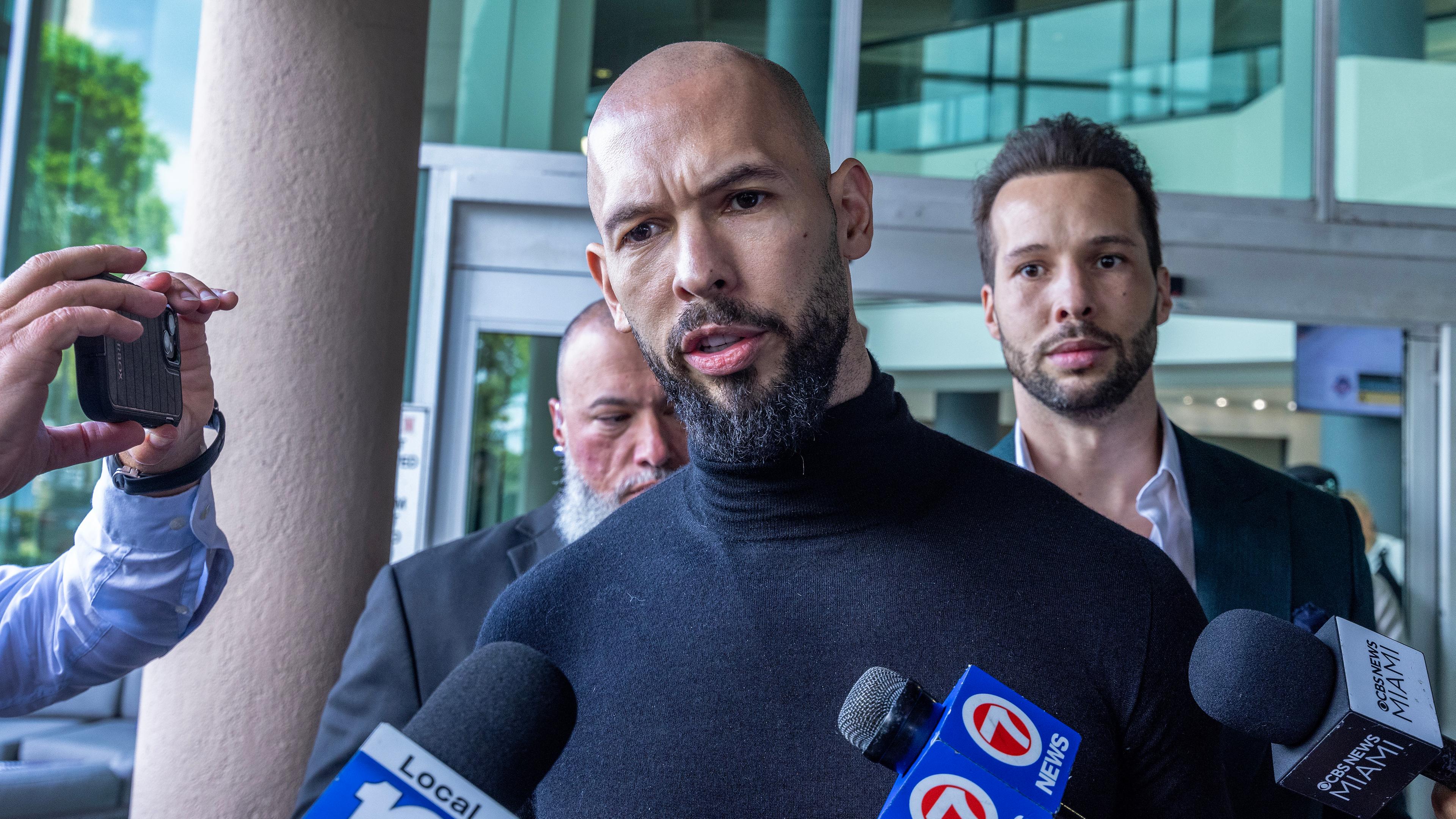 Der ehemalige Profi-Kickboxer und Social-Media-Influencer Andrew Tate (C) spricht mit den Medien, als er und sein Bruder Tristan (R) am 27. Februar 2025 am Fort Lauderdale Airport in Fort Lauderdale, Florida, USA, ankommen. 