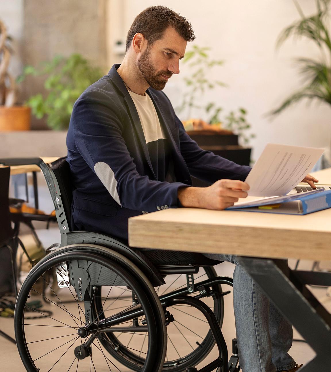 Ein Mann sitz im Rollstuhl am Arbeitsplatz