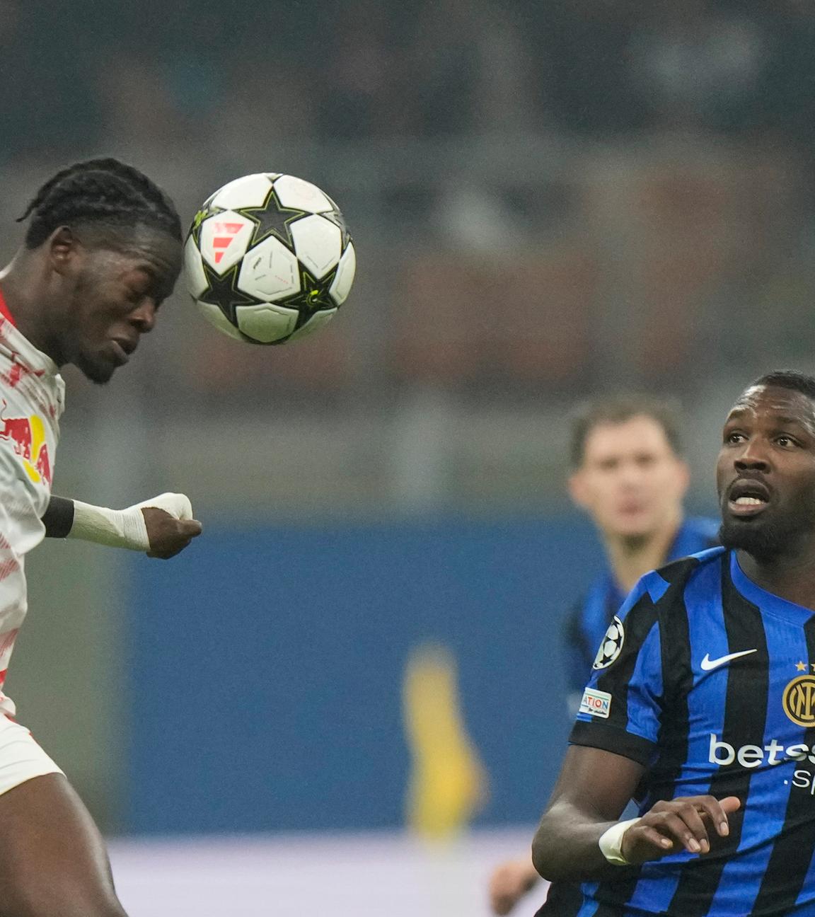 Leipzigs Castello Lukeba (li.) gegen Marcus Thuram von Inter Mailand