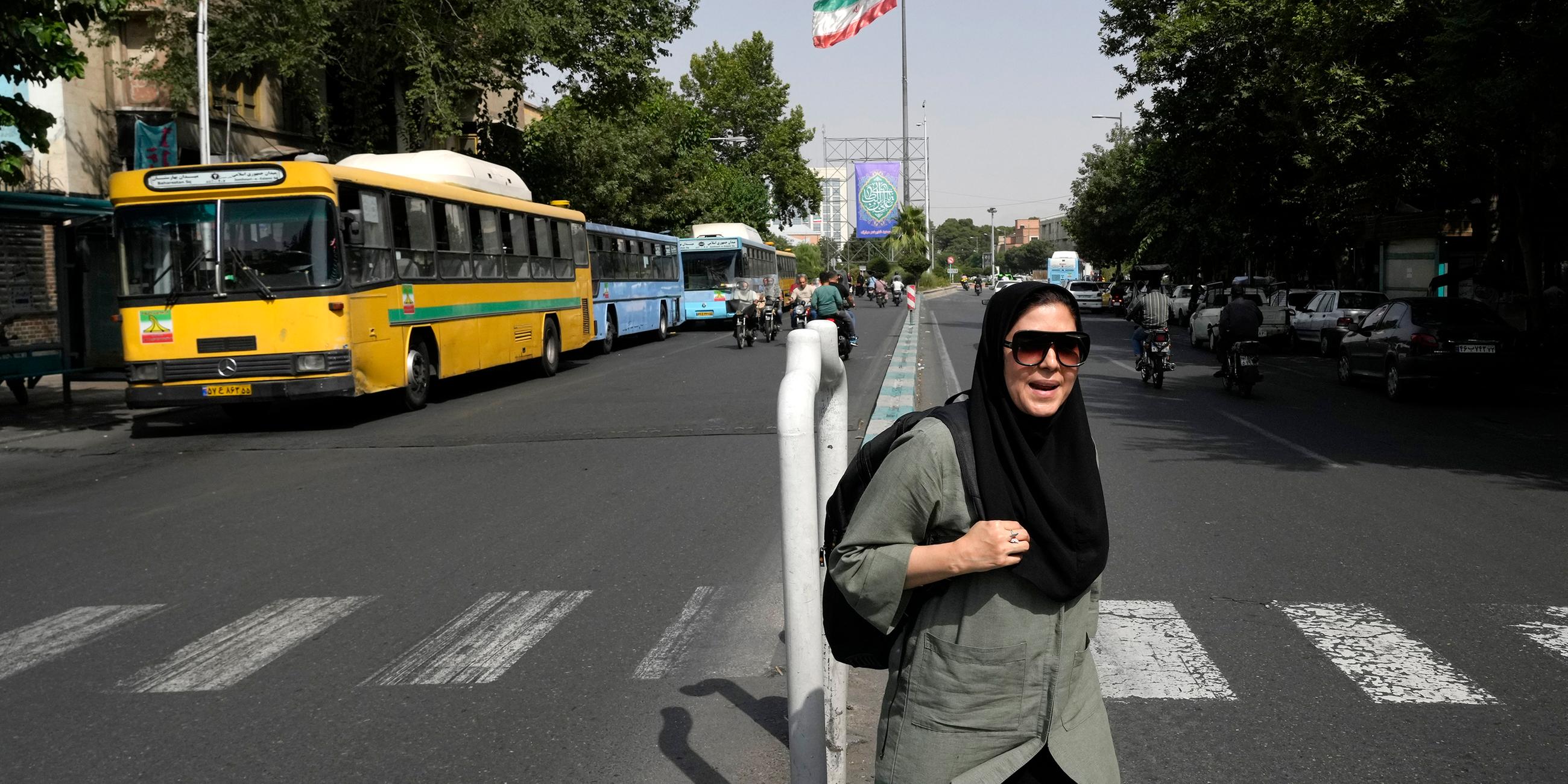 Eine Frau läuft auf einer Straße in Teheran, Iran.