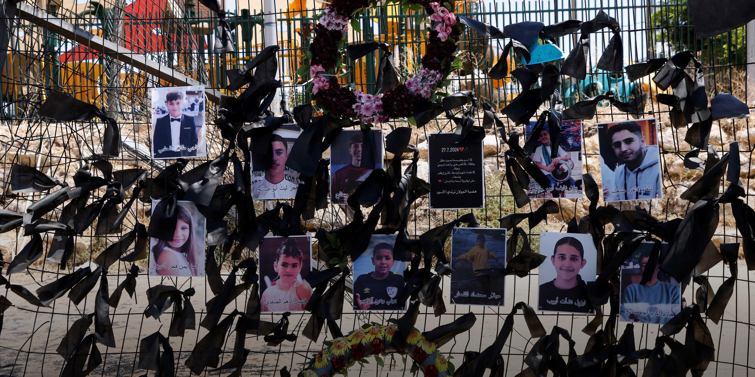 Die Bilder der bei einem Raketenanschlag auf den Golanhöhen getöteten Kinder hängen am Zaun eines Fußballplatzes