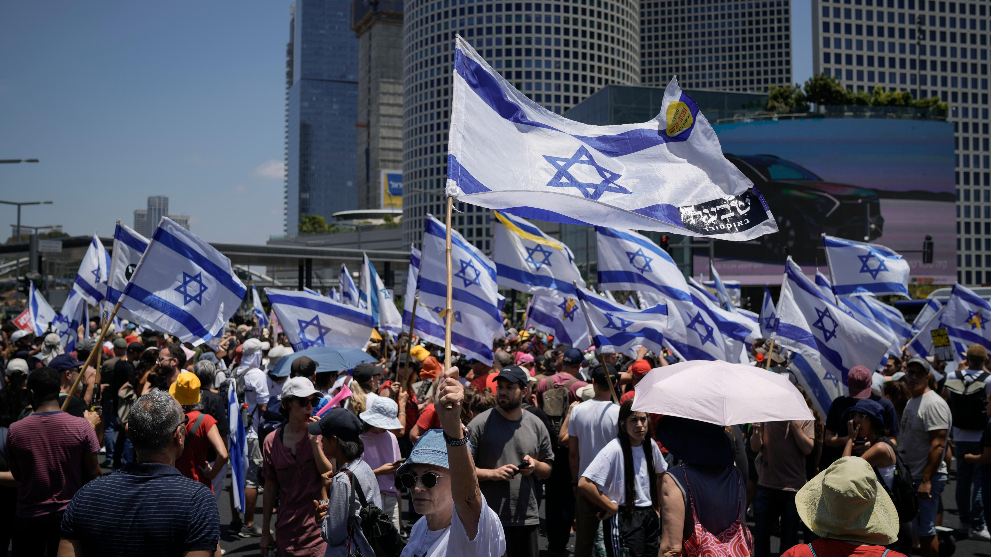 Demonstranten wehen mit israelischen Flaggen bei einem Protest zur Freilassung der Geiseln in der Gewalt der Hamas.