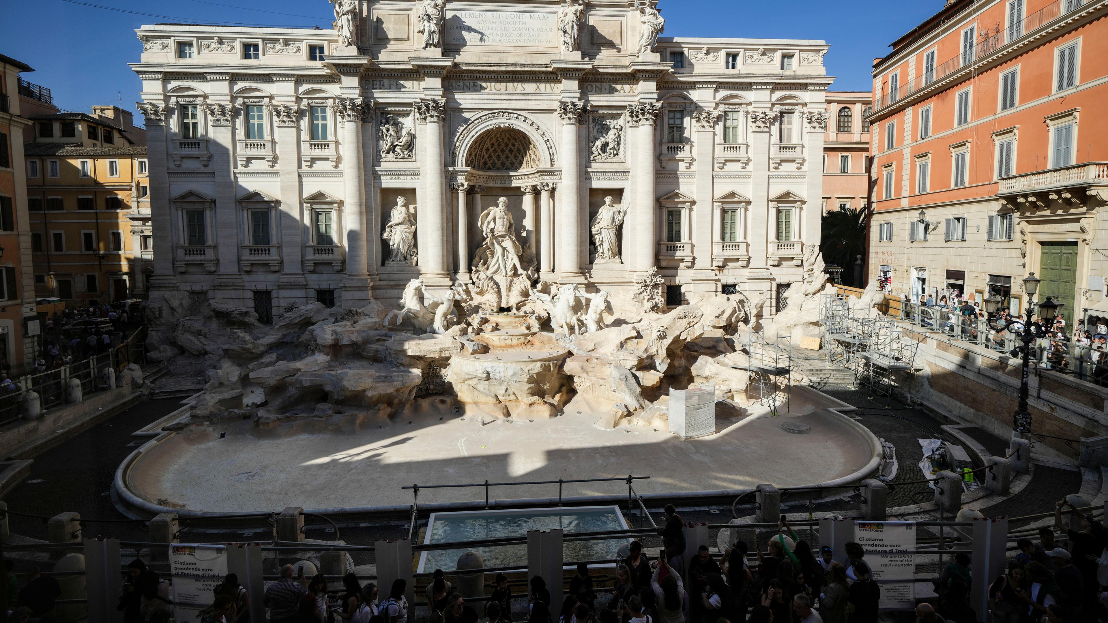 Italian, Rom: Vor dem Trevi-Brunnen ist ein kleiner Teich zu sehen, in den Touristen ihre Münzen werfen können, da der Brunnen geleert wurde, um Wartungsarbeiten durchzuführen