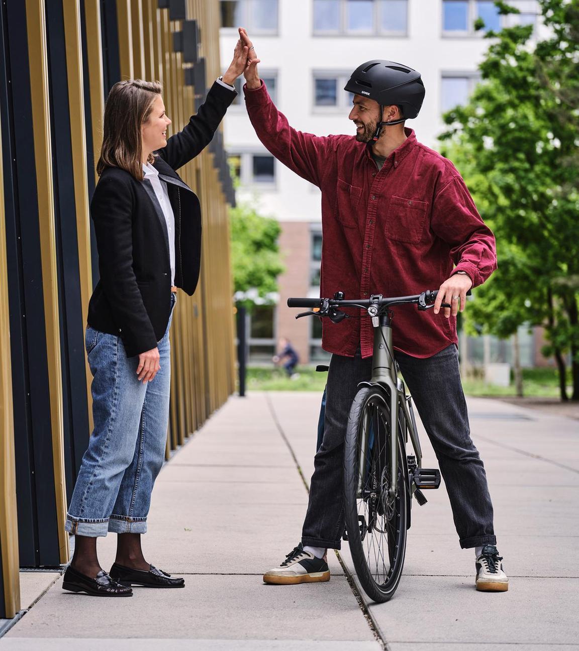 Ein Fahrradfahrer gibt seiner Arbeitgeberin die Hand.