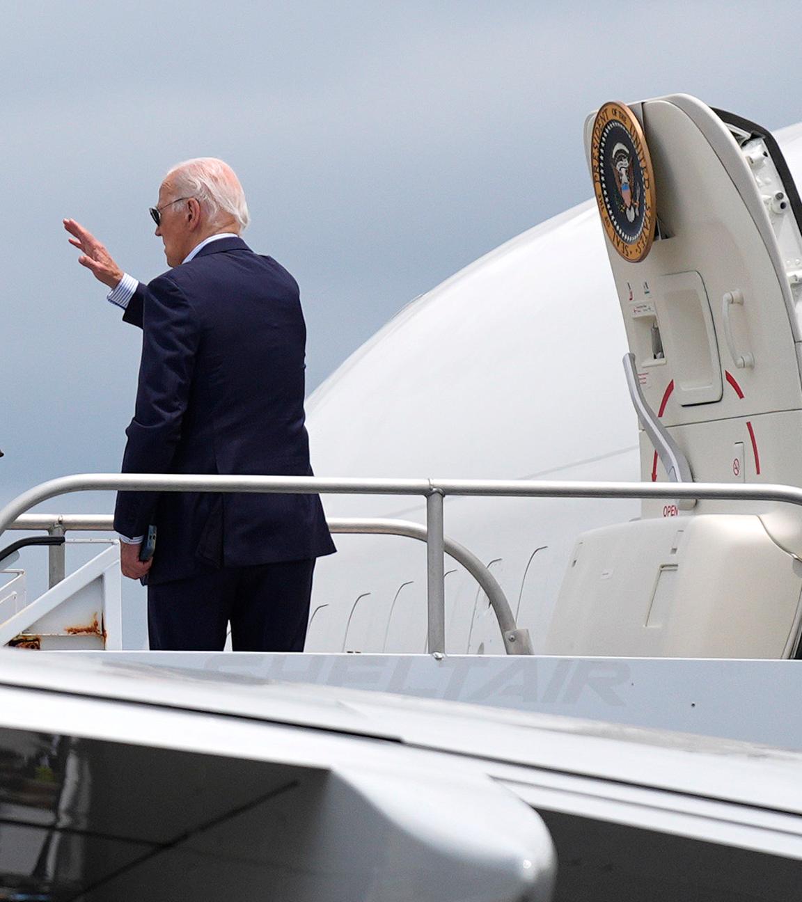 Joe Biden winkt beim Einstieg in sein Flugzeug.