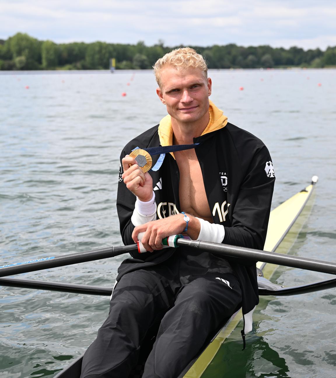 Oliver Zeidler aus Deutschland sitzt in seinem Boot und jubelt mit seiner Goldmedaille.