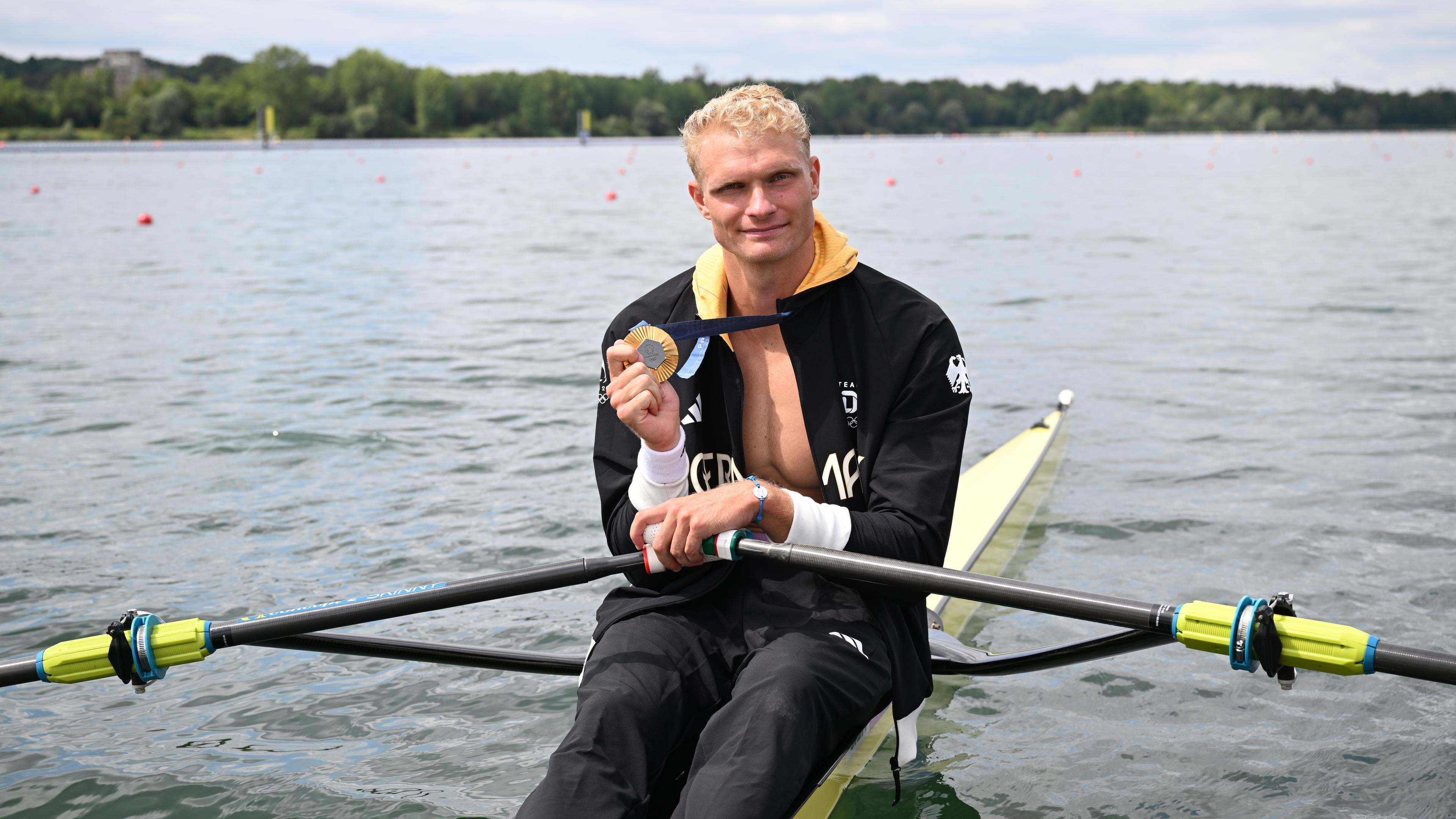 Oliver Zeidler aus Deutschland sitzt in seinem Boot und jubelt mit seiner Goldmedaille.