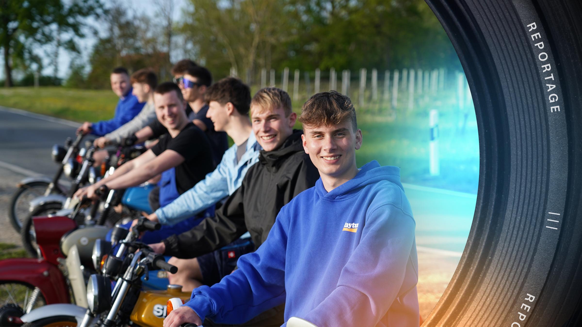 "ZDF.reportage: Jung im Osten – Wie wir wirklich leben": Jason aus Flurstedt und andere Jugendlichen sitzen auf Simson-Mopeds und lächeln in die Kamera. Im Hintergrund verläuft eine schmale Landstraße an der Bäume stehen.