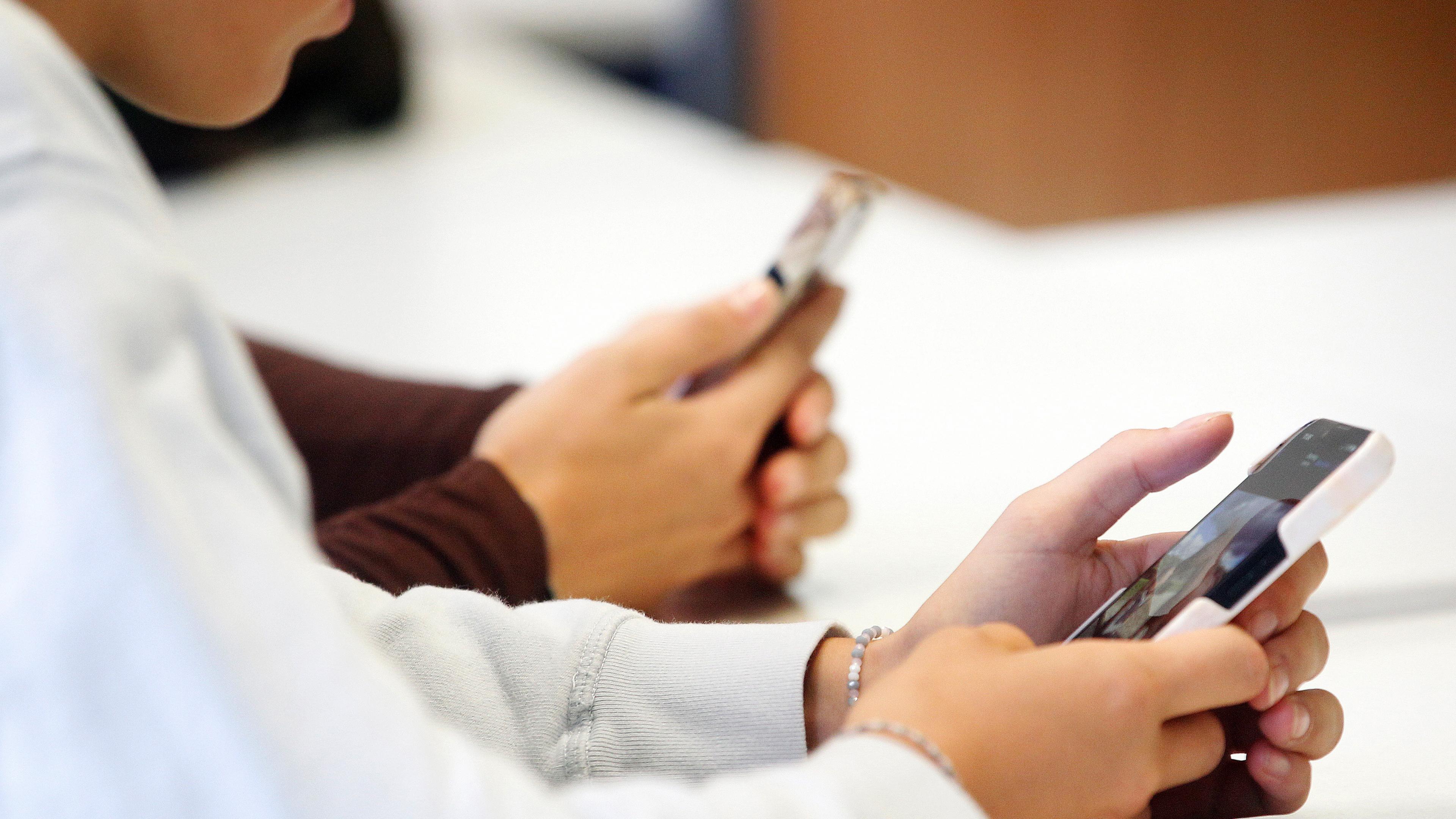 Schülerinnen des Biologie-Leistungskurses vom Max-Plank-Gymnasium benutzen während eines Vortrags über die Anwendungen von Künstlicher Intelligenz (KI) ihr Smartphone im Unterrich