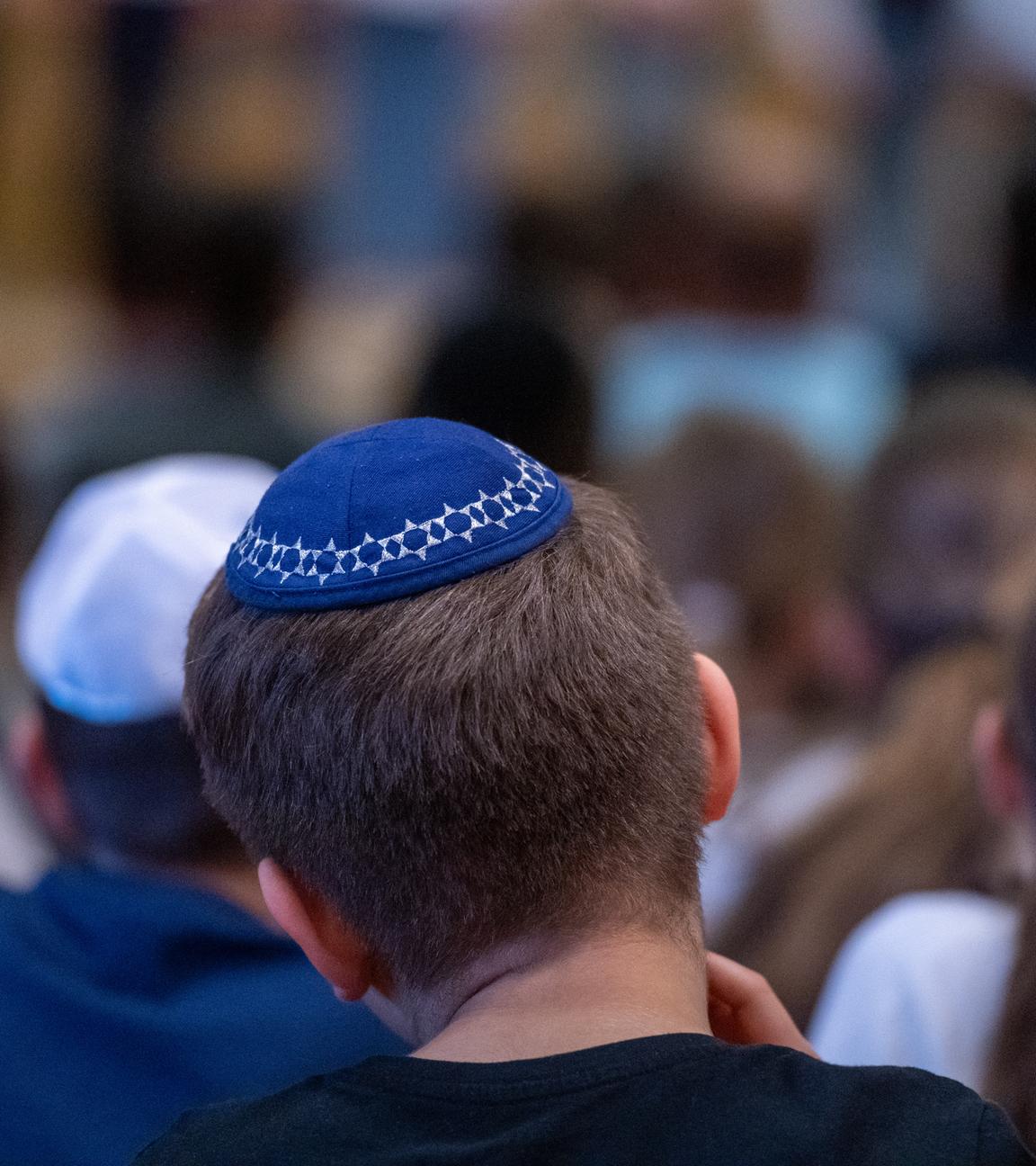 Ein Schüler mit einer Kippa sitzt in der Aula einer Schule. (Archivbild)