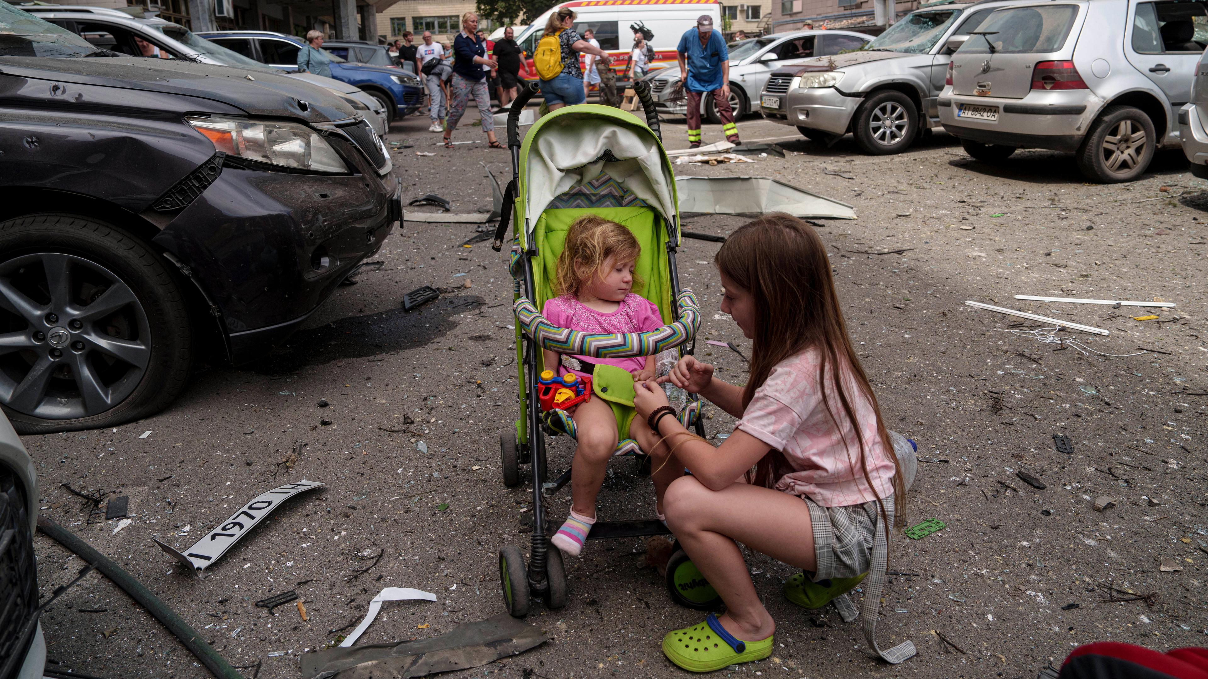 Kinder warten in der Nähe des Okhmatdyt-Kinderkrankenhauses, das von russischen Raketen getroffen wurde.
