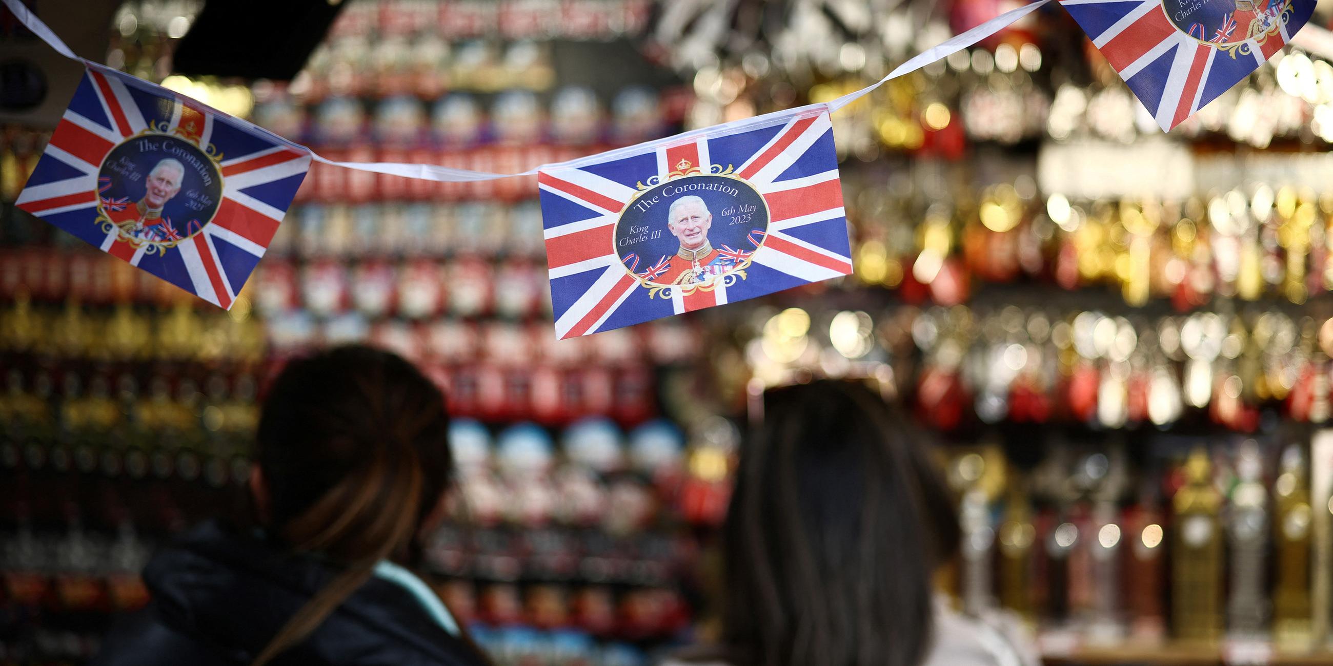 Menschen stöbern in einem Souvenir-Kiosk, der Artikel für die Krönung von König Karl III. ausstellt, in London.