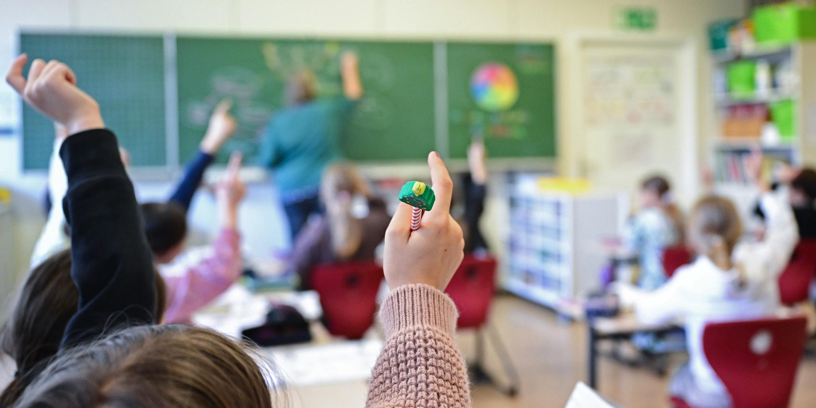 Schüler melden sich in einer vierten Klasse in einer Grundschule in Stuttgart