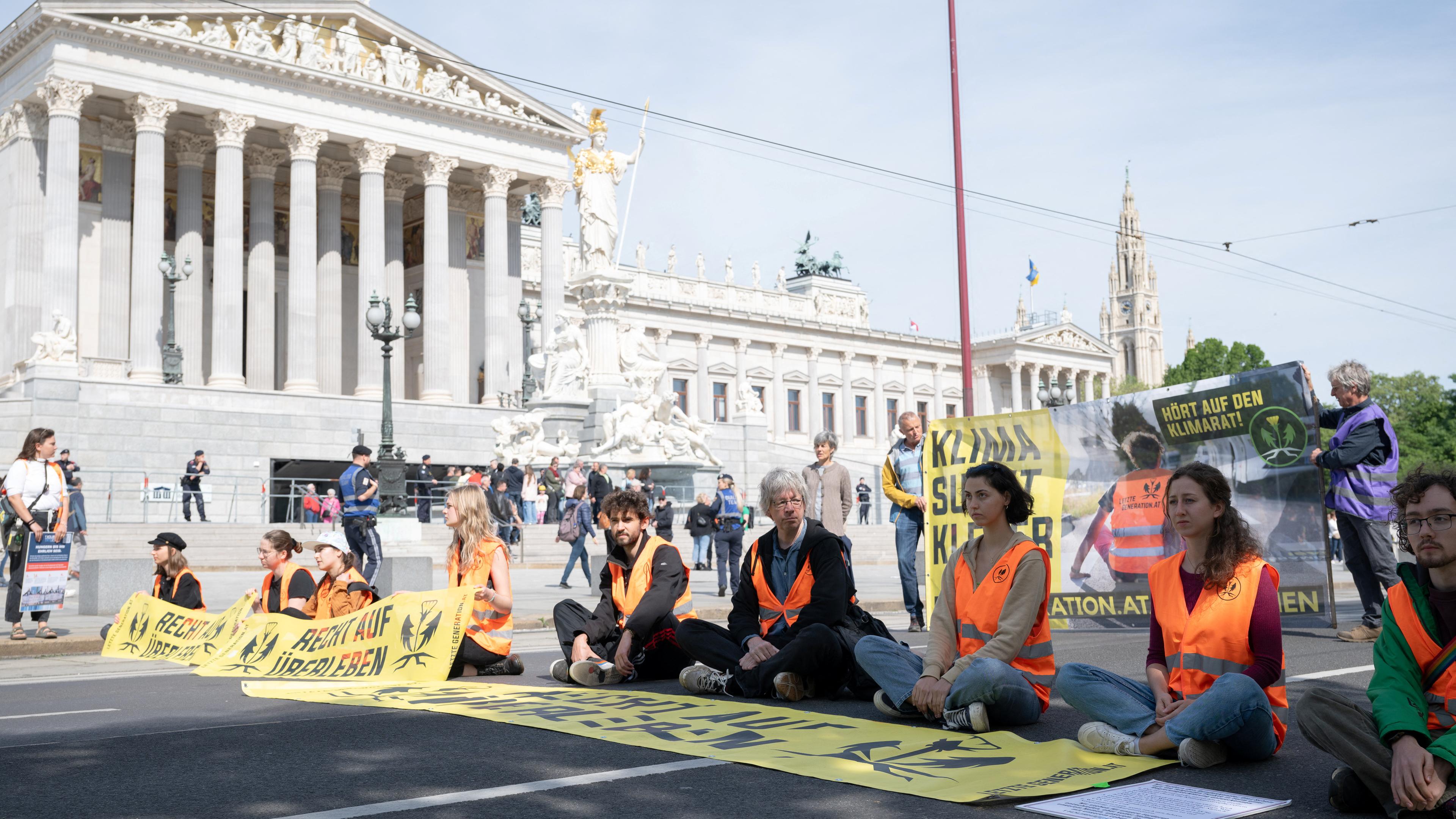 Klimaaktivisten blockieren die Straße vor dem österreichischen Parlament in Wien