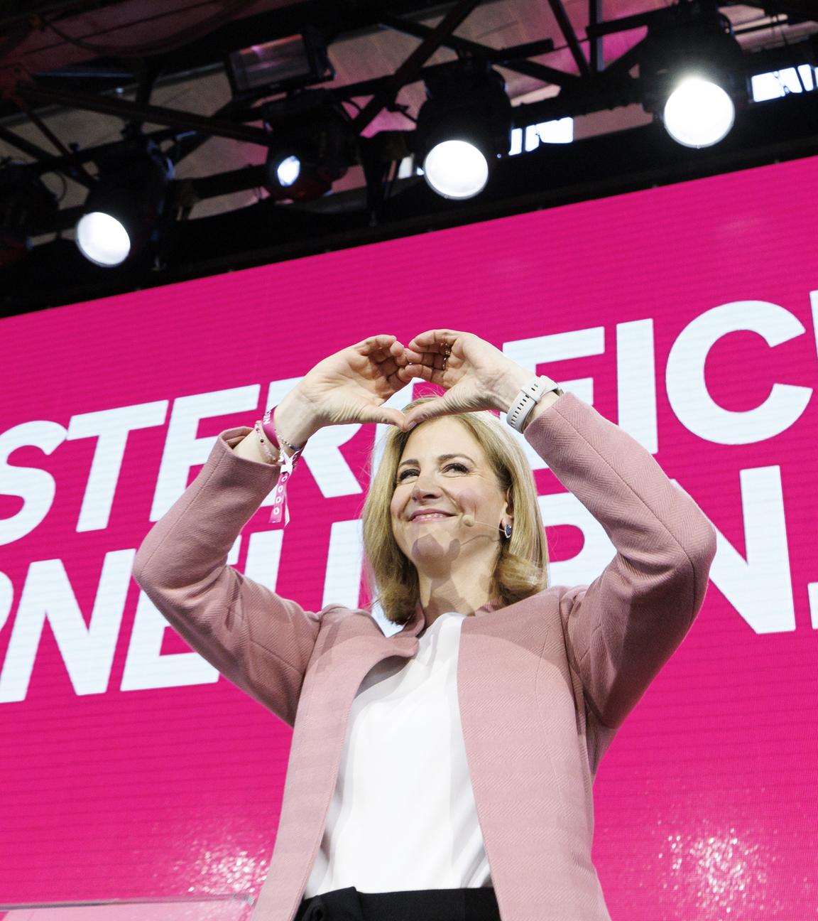 Die designierte Außenministerin Beate Meinl-Reisinger (Neos) zeigt mit den Händen ein Herz bei einer Mitgliederversammlung ihrer Partei mit Abstimmung über das Arbeitsprogramm der Dreierkoalition in Wien. 