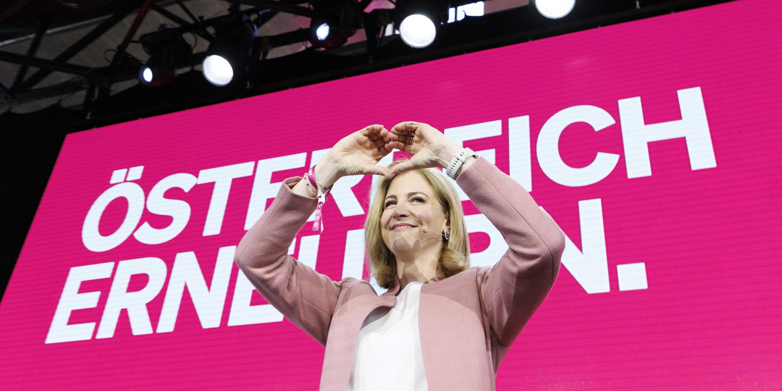 Die designierte Außenministerin Beate Meinl-Reisinger (Neos) zeigt mit den Händen ein Herz bei einer Mitgliederversammlung ihrer Partei mit Abstimmung über das Arbeitsprogramm der Dreierkoalition in Wien. 