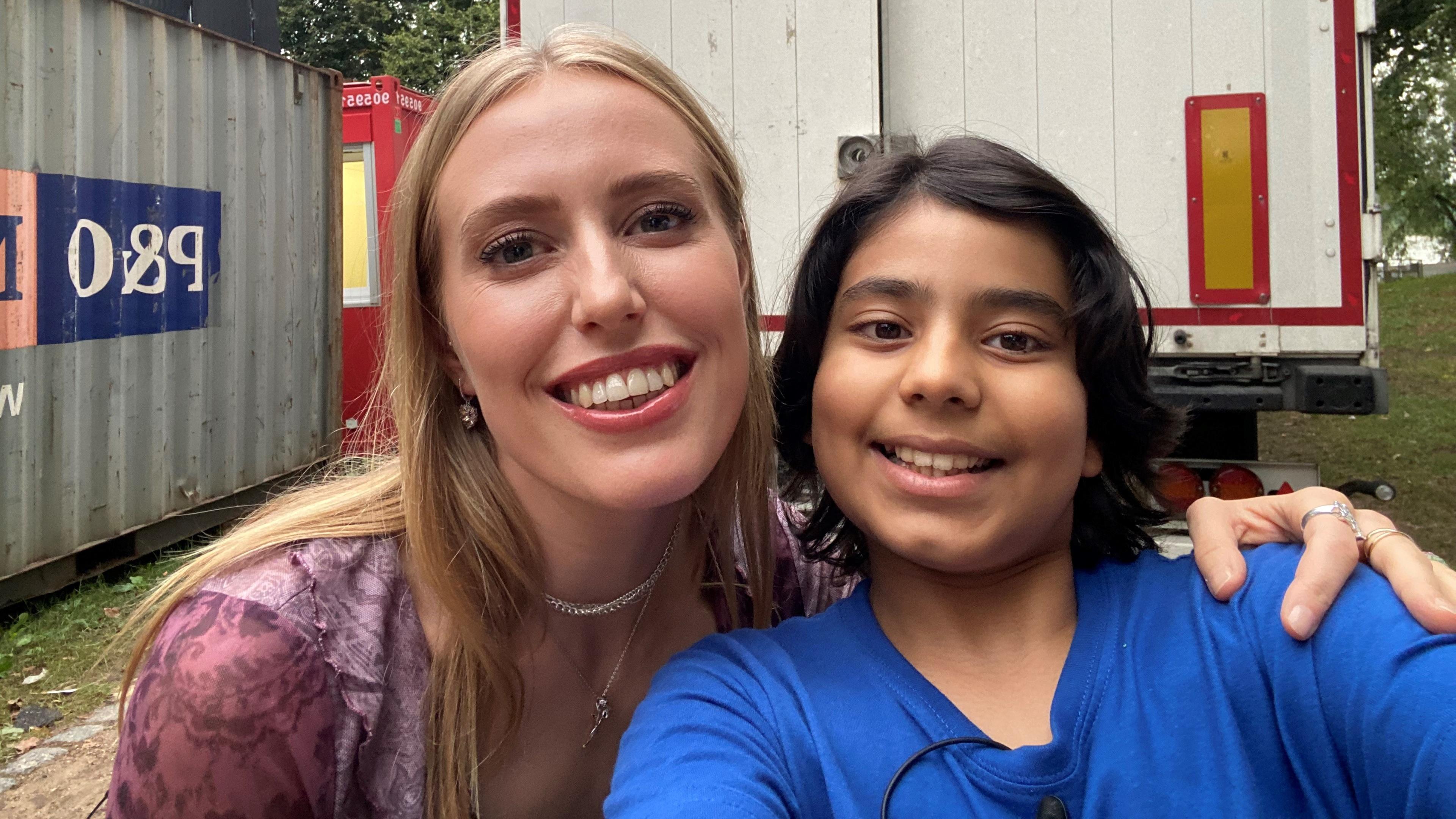 Kinderreporter Vivaan und Sängerin LEA machen ein Selfie, stehen nebeneinander und lachen in die Kamera