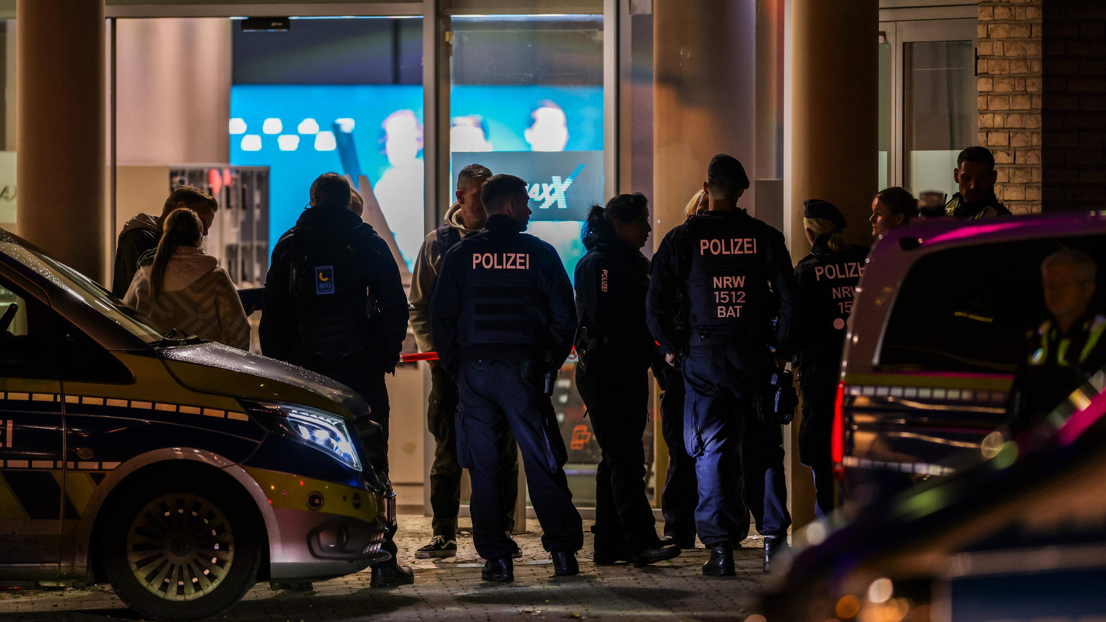 Polizeibeamte und Rettungsdienst stehen vor dem Cinemaxx-Kino in der Krefelder Innenstadt. 