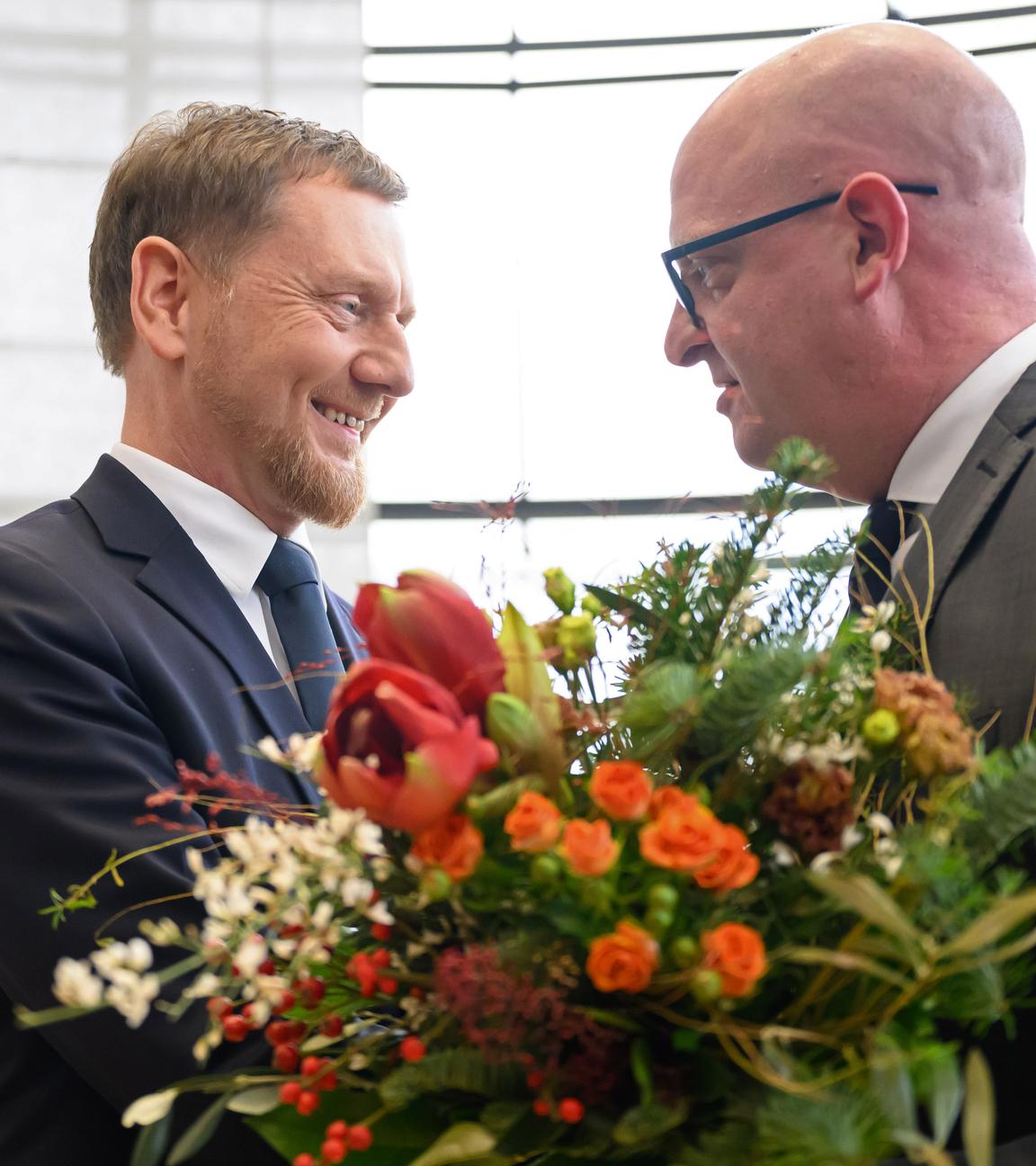 Michael Kretschmer nimmt nach der Wahl zum Ministerpräsidenten von Sachsen Glückwünsche und Blumen von Henning Homann, Co-Vorsitzender der SPD in Sachsen, entgegen.