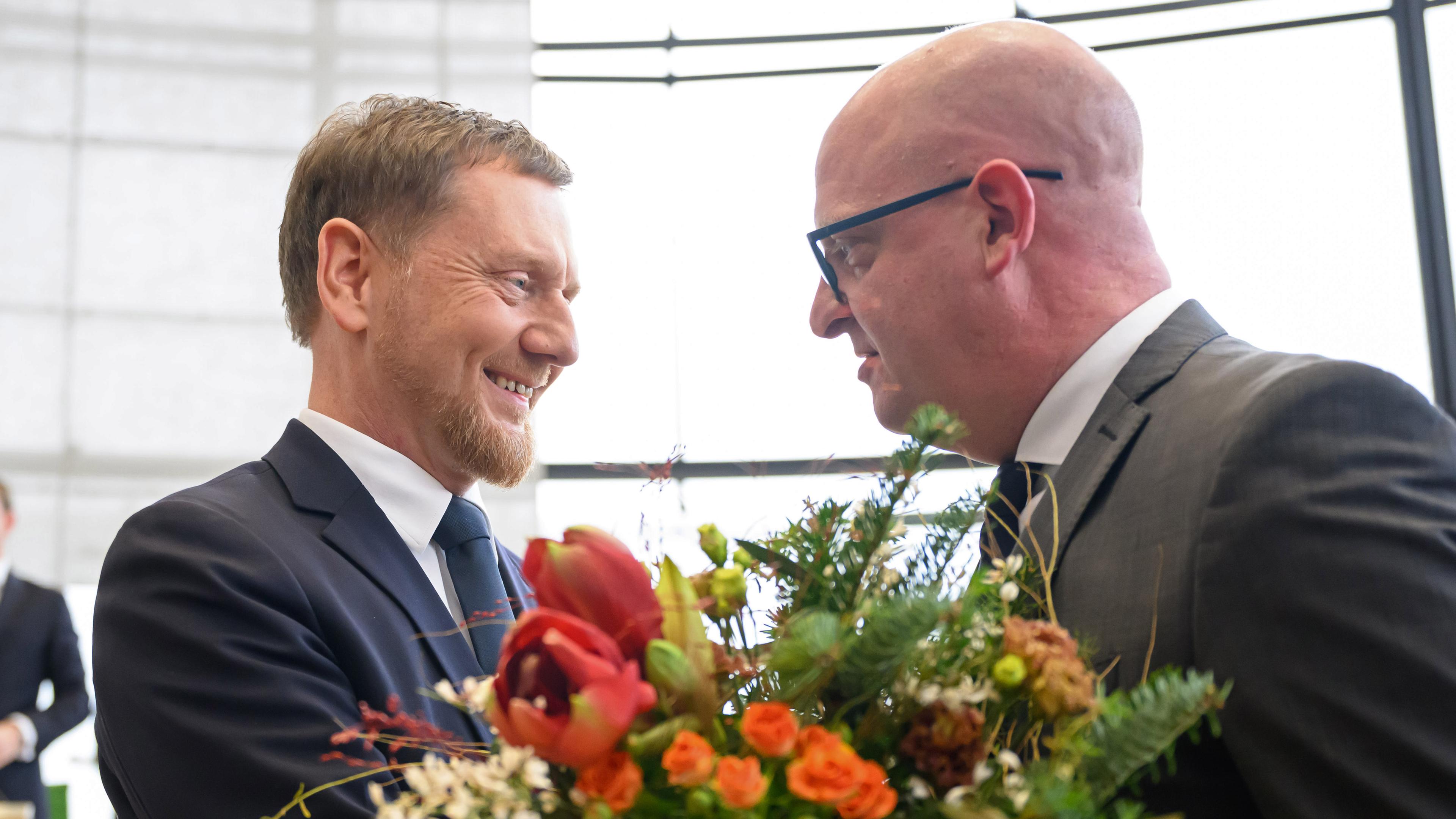 Michael Kretschmer nimmt nach der Wahl zum Ministerpräsidenten von Sachsen Glückwünsche und Blumen von Henning Homann, Co-Vorsitzender der SPD in Sachsen, entgegen.