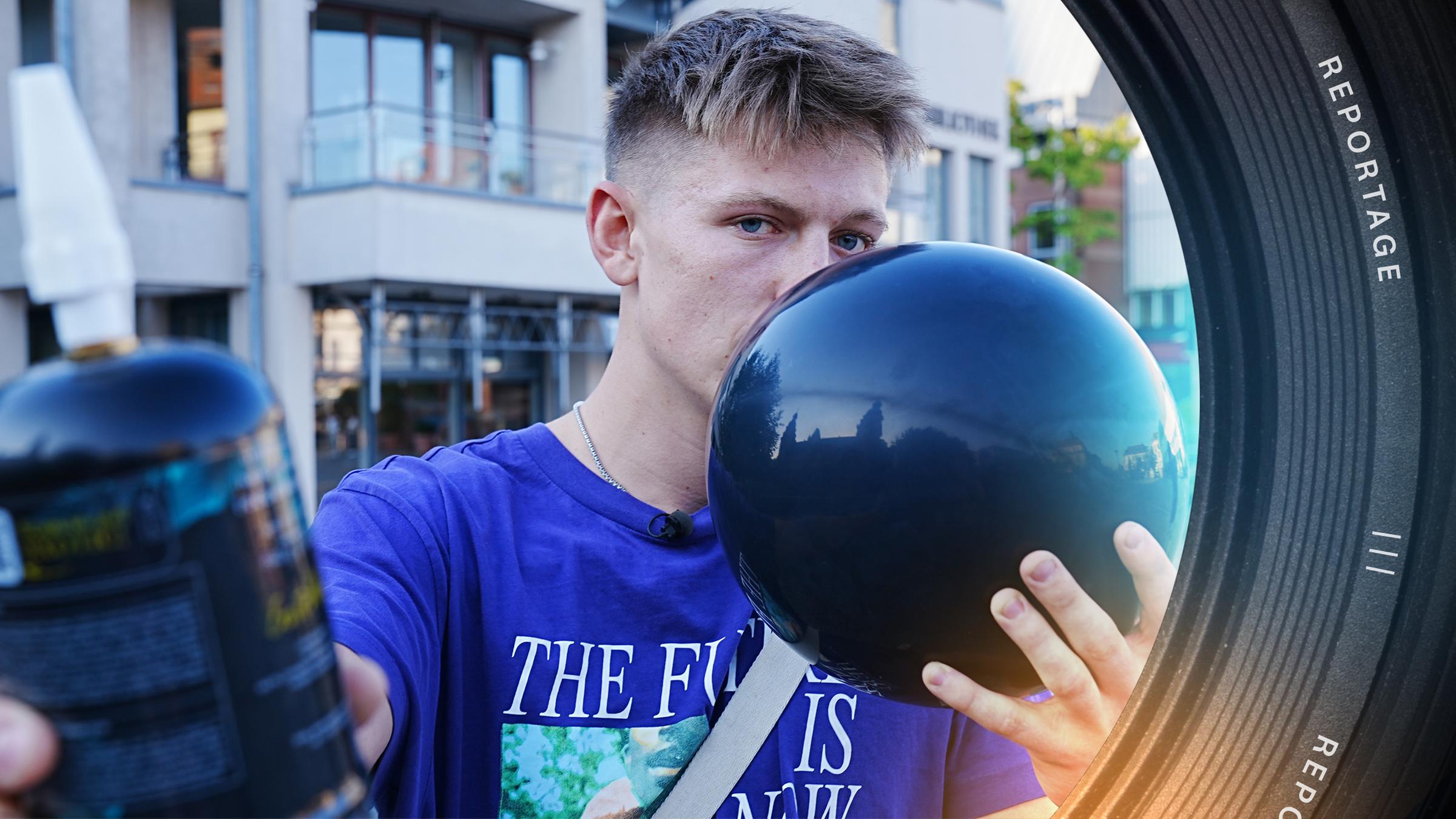 Ein junger Mann hält sich mit einer Hand einen Luftballon vor den Mund. Mit der anderen Hand streckt er eine Kartusche Lachgas in die Kamera.