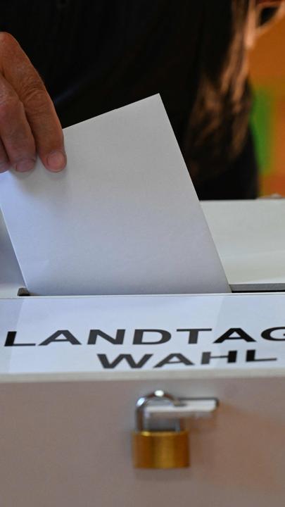 Ein Wähler gibt bei der Landtagswahl in Brandenburg seinen Stimmzettel in die Wahlurne ab.