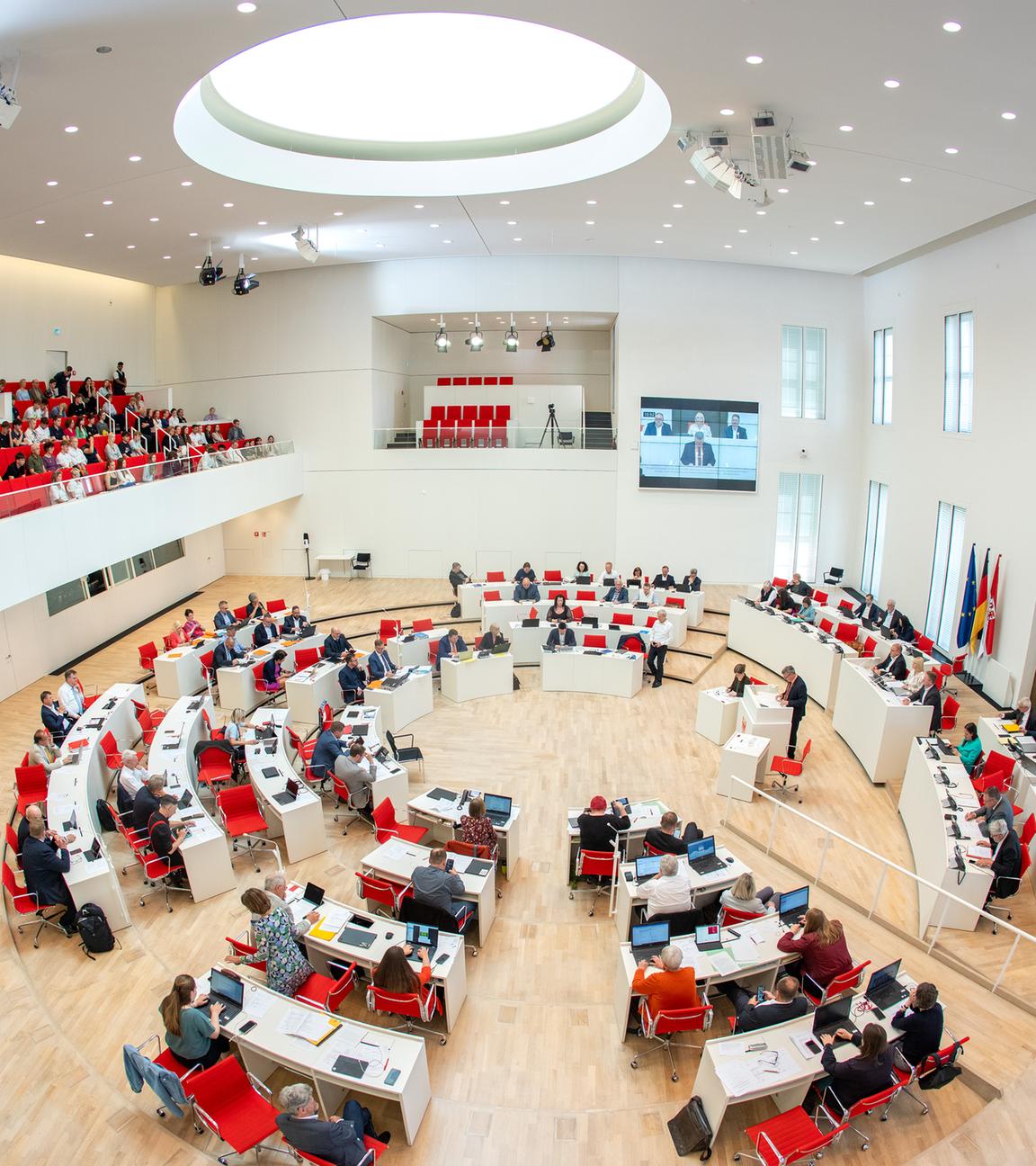 Abgeordnete und Besucher auf der Tribüne verfolgen eine Debatte im Landtag von Brandenburg.