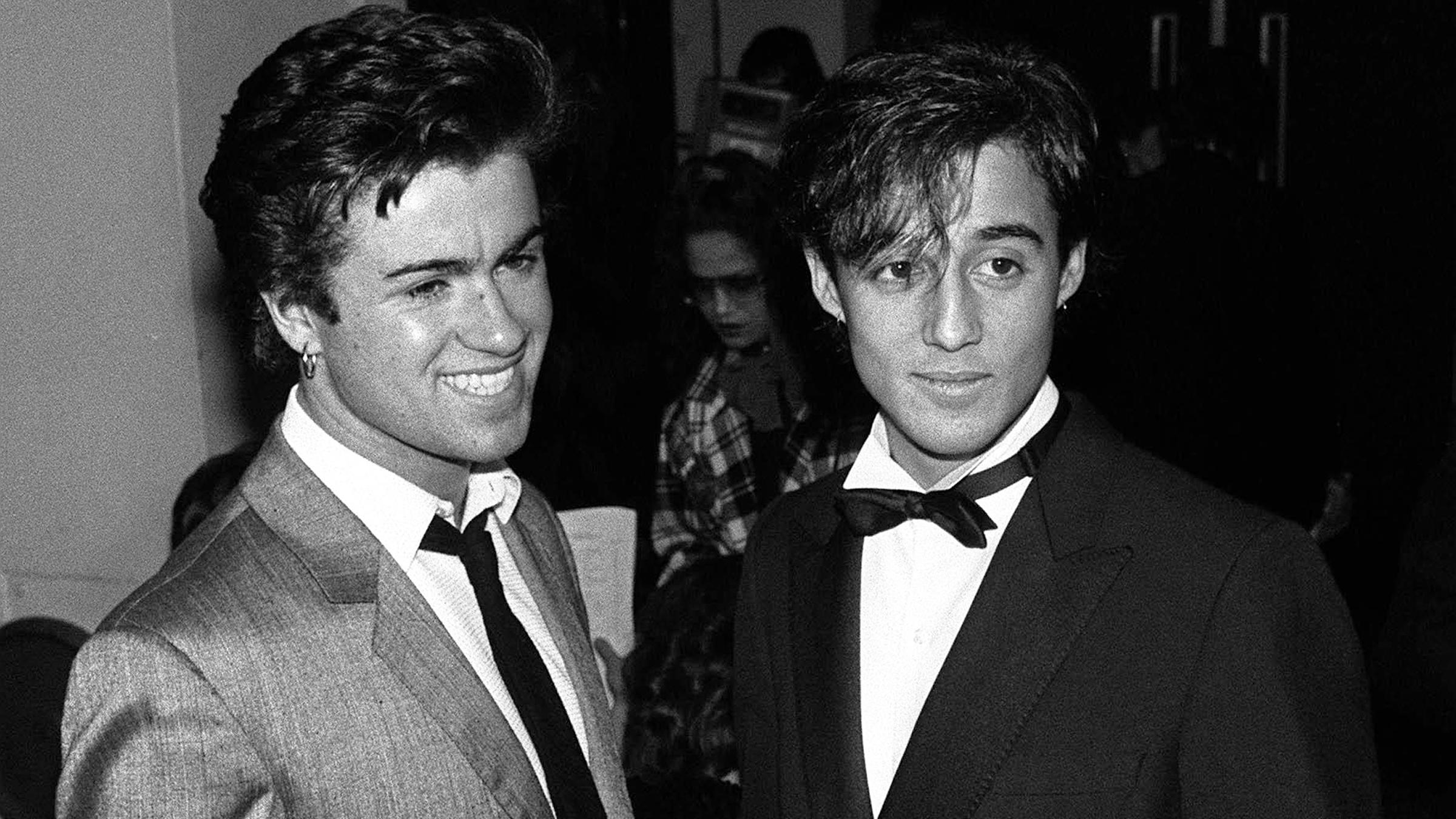 George Michael und Andrew Ridgeley lachend.