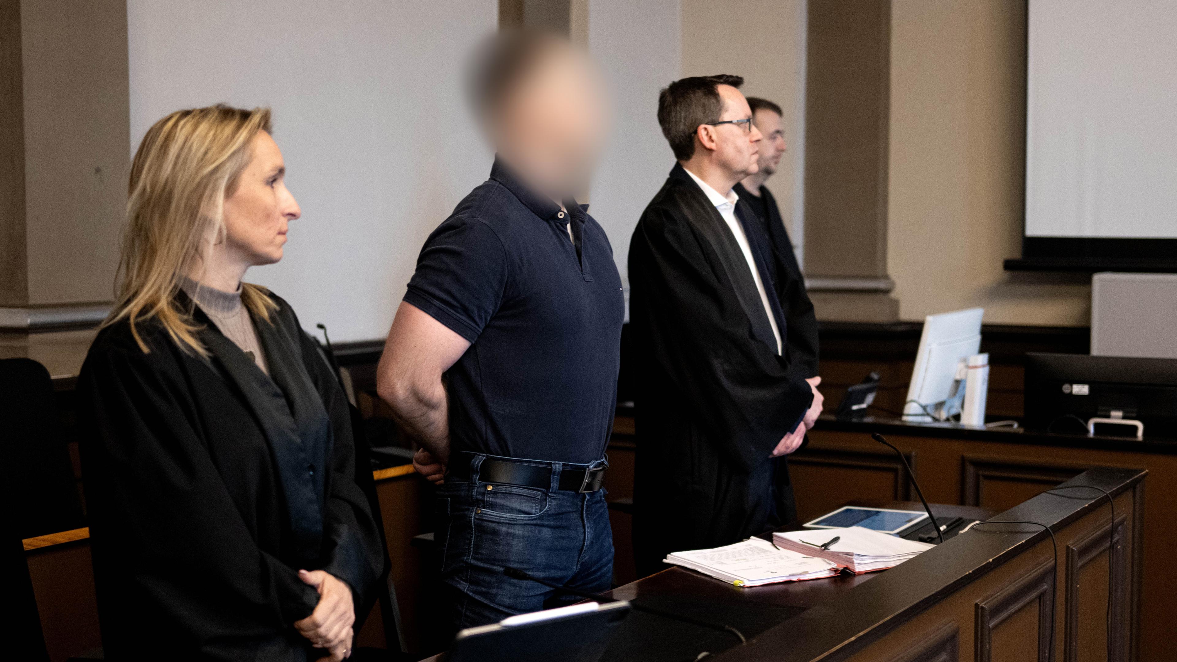 Der Angeklagte steht neben seinen Verteidigern Daniela Post (l) und René Lancker (r) im Gerichtssaal vom Landgericht Verden. 