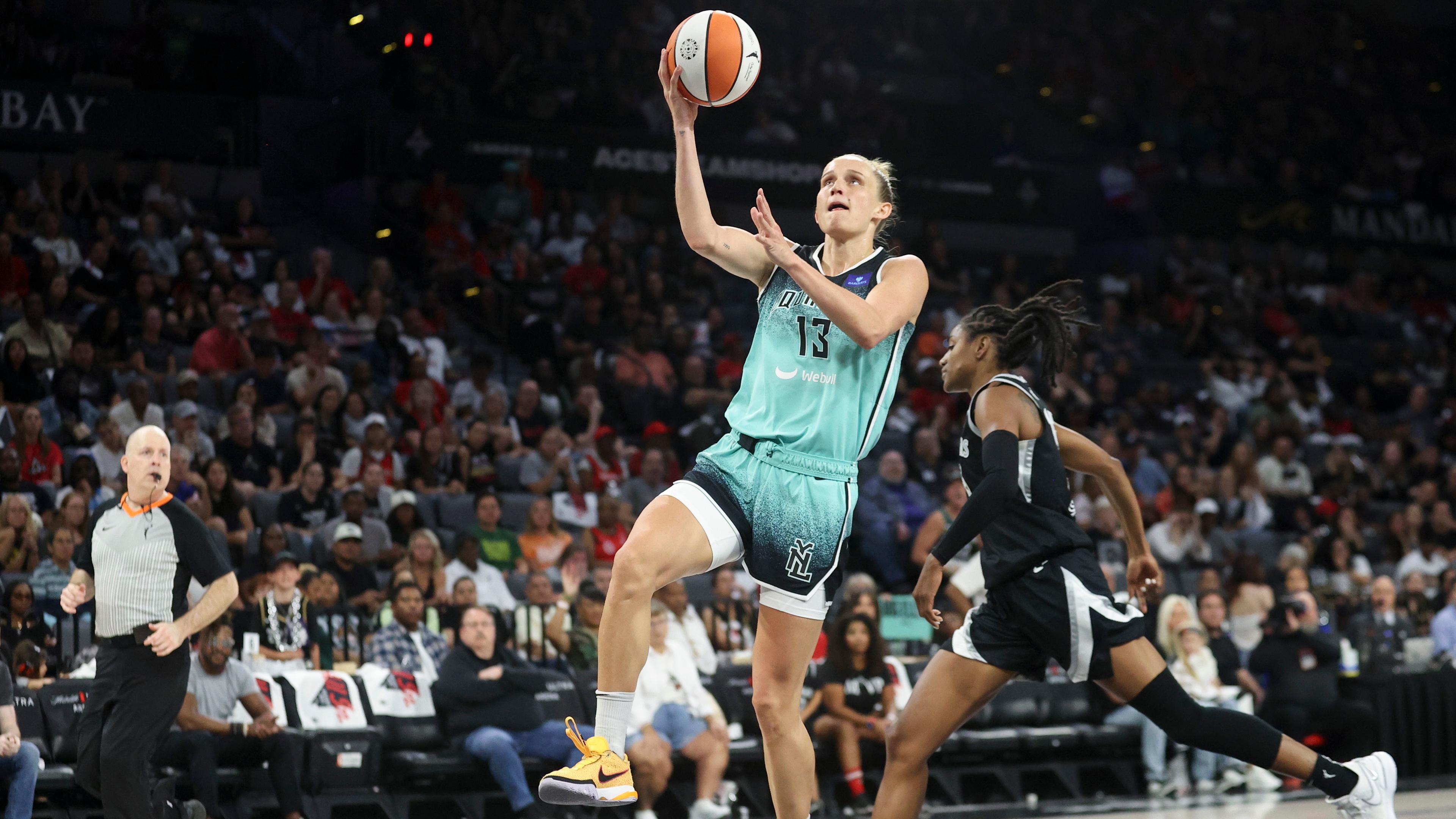 New York Liberty-Forward Leonie Fiebich (13) wirft einen Korb an der Las Vegas Aces-Guard Tiffany Hayes (15) vorbei. 