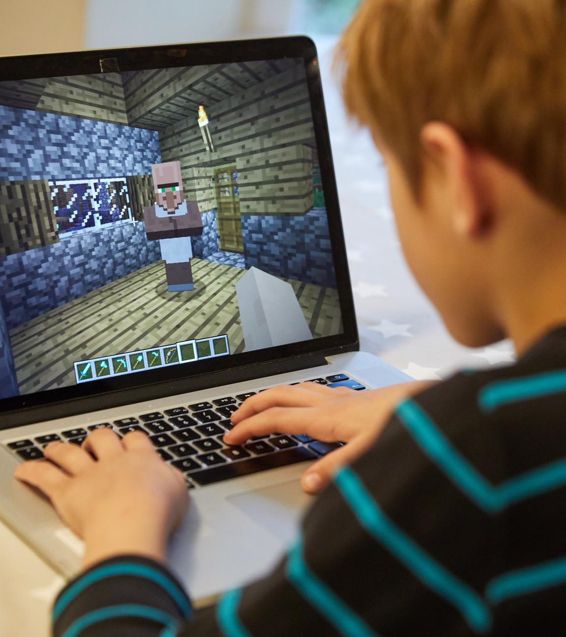 Mingus (9) spielt auf einem Laptop das Open-World-Computerspiel Minecraft. 