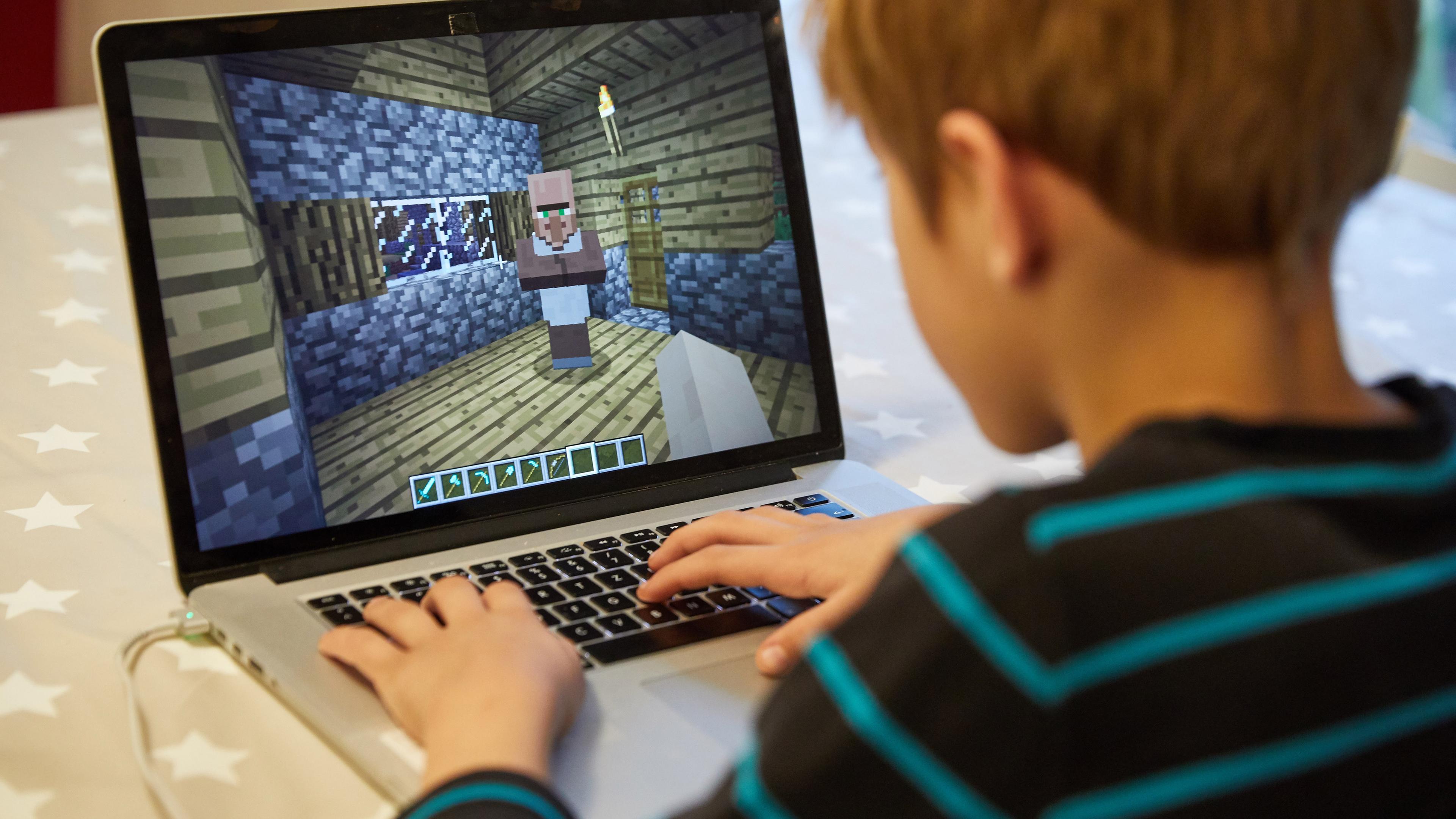 Mingus (9) spielt auf einem Laptop das Open-World-Computerspiel Minecraft. 