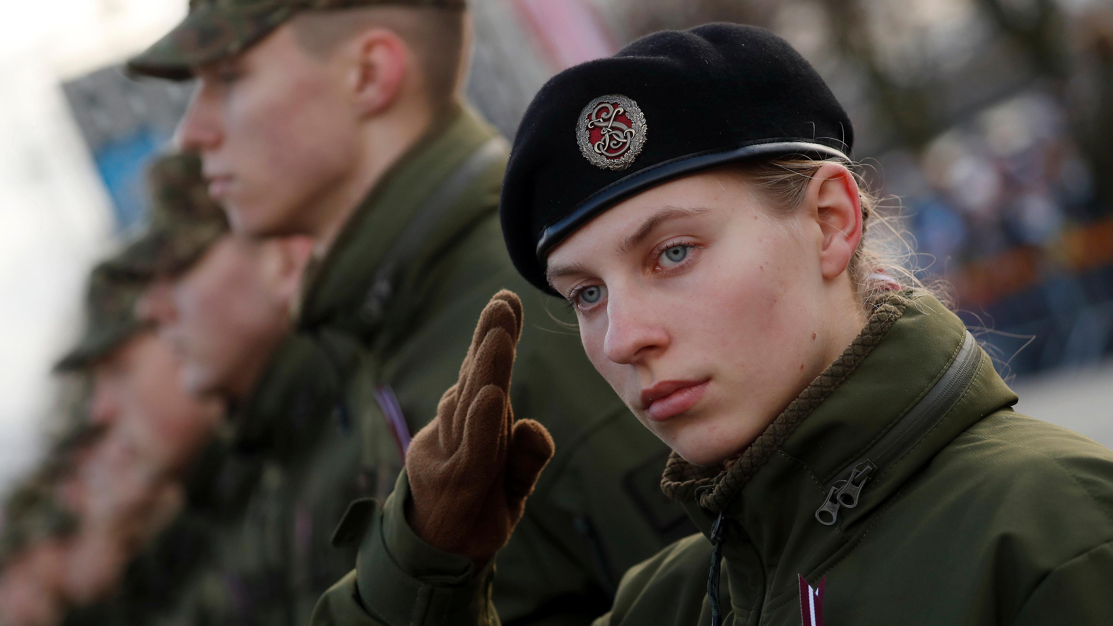 Es ist eine salutierende Frau des lettischen Militärs zu sehen.