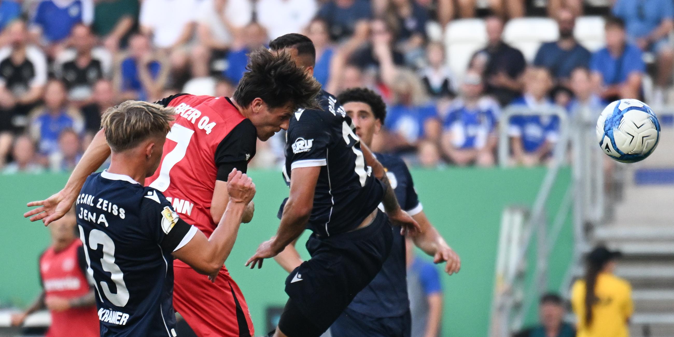 DFB-Pokal, FC Carl Zeiss Jena - Bayer 04 Leverkusen, 1. Runde: Leverkusens Jonas Hofmann (M.) setzt sich gegen Jenas Spieler Paul Krämer (l.) und Justin Schau durch und erzielt den Treffer zum 0:1.