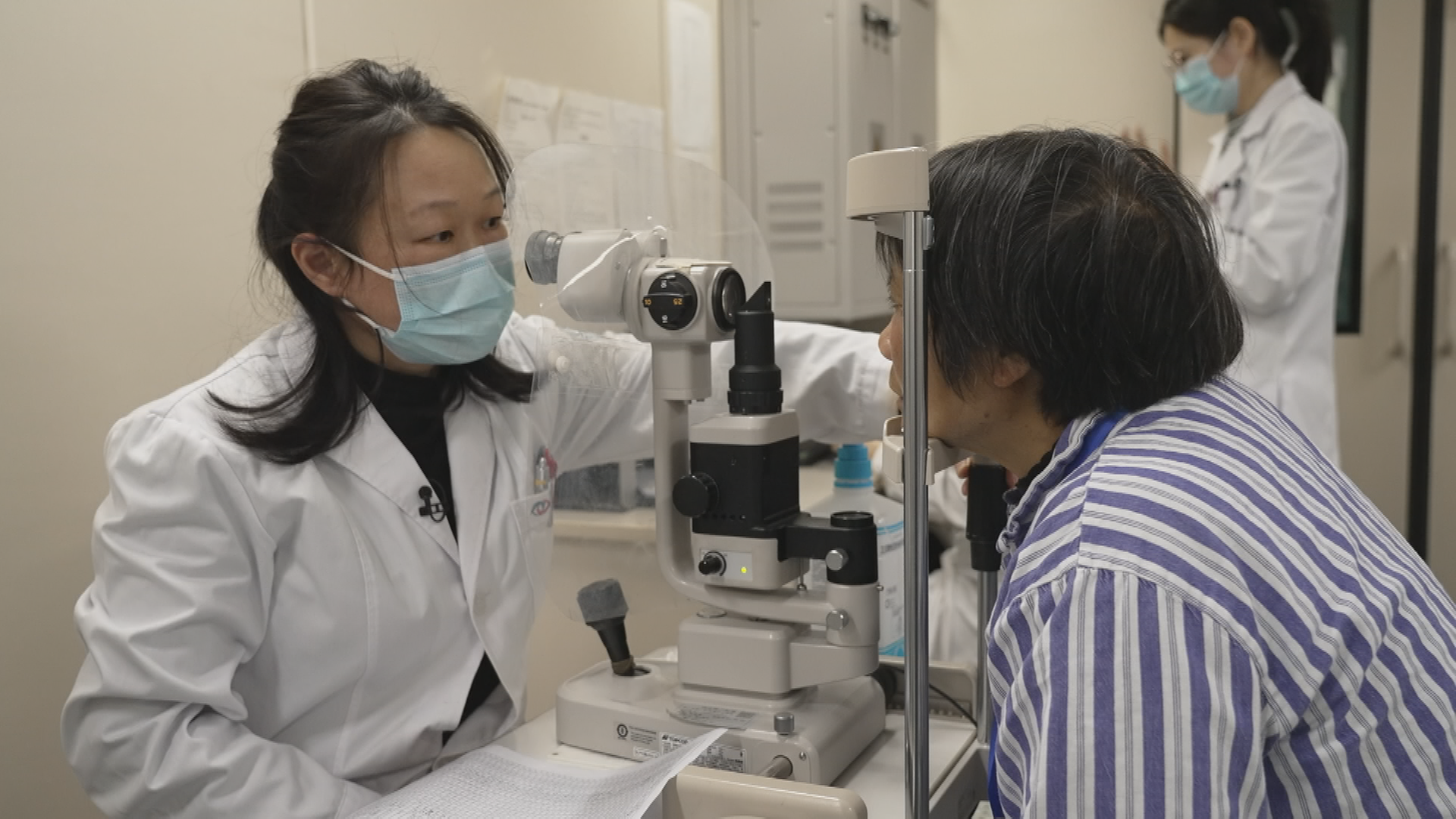 Eine Ärtzin untersucht die Augen einer älteren Frau in einem Klinik-Zug in China.