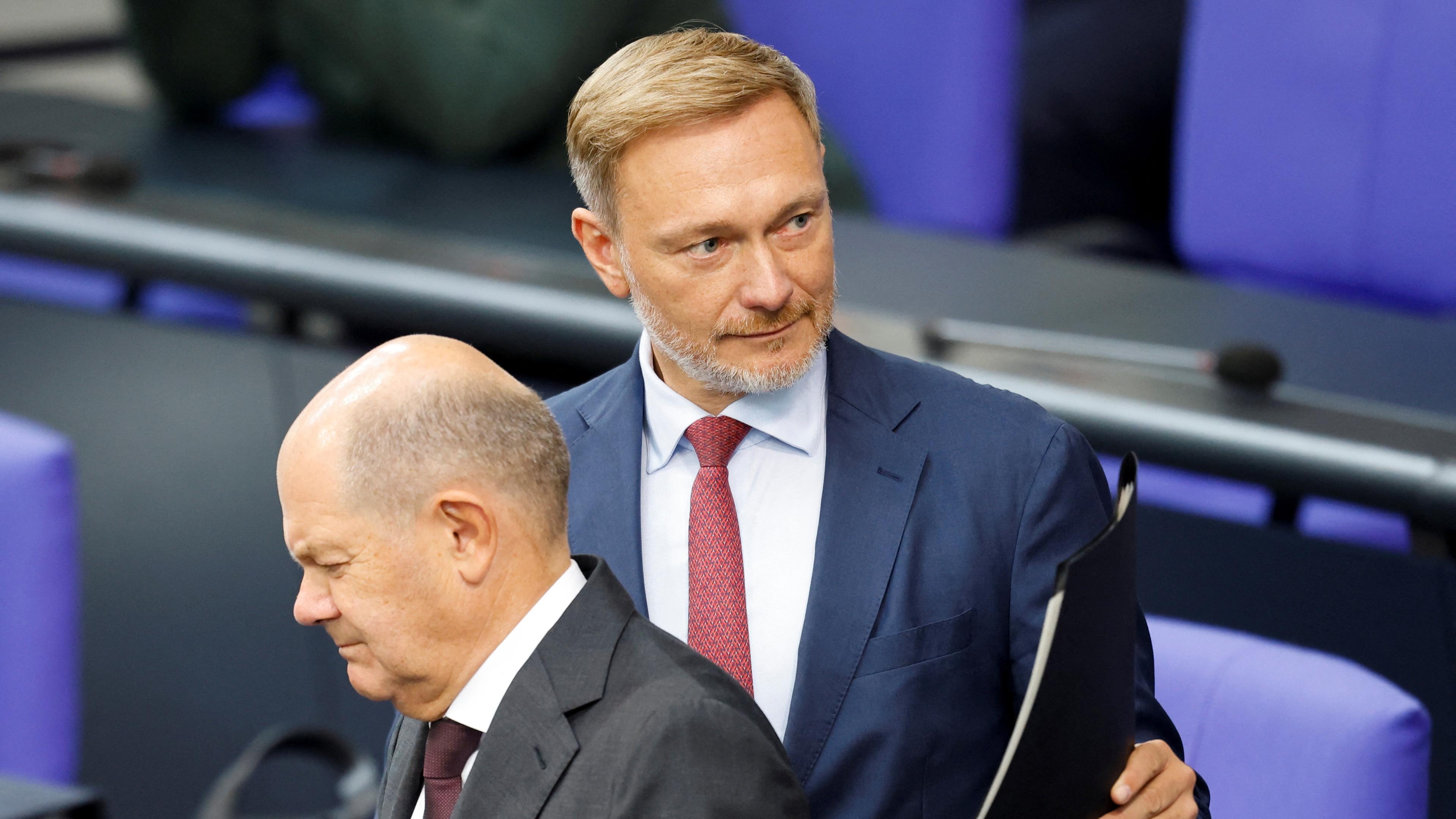 Bundesfinanzminister Lindner steht neben Bundeskanzler Scholz im Bundestag. 