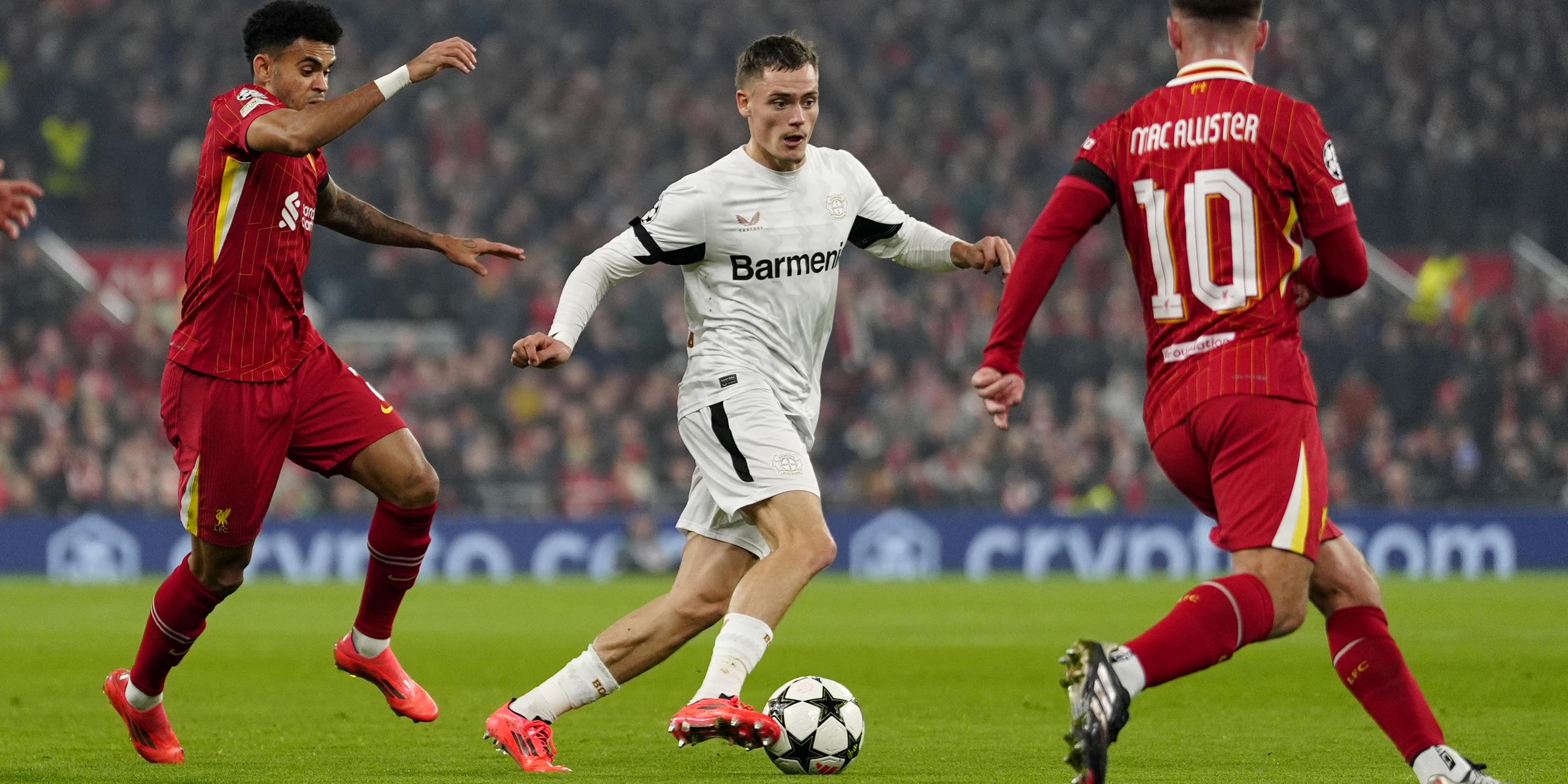 Champions League: Leverkusens Florian Wirtz (M) und Liverpools Luis Diaz (l) kämpfen um den Ball