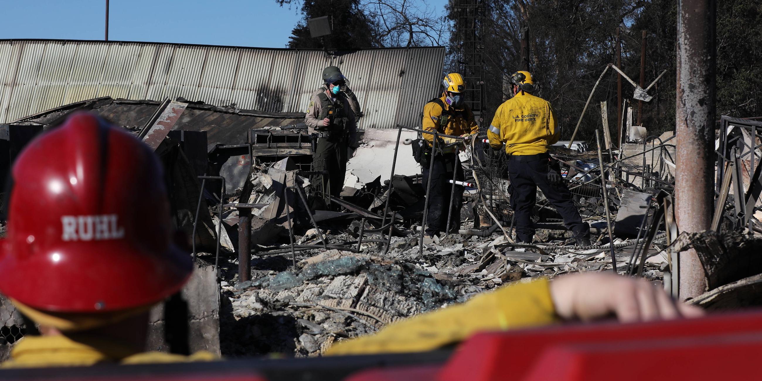 Los Angeles Fire Rescue- und San Diego Urban Search and Rescue-Teams durchsuchen, unterstützt von Vertretern des Los Angeles County Sheriff s Department, am 15. 01. 2025 in Altadena, Kalifornien, USA, nach durch Waldbrände beschädigten Gebäuden.