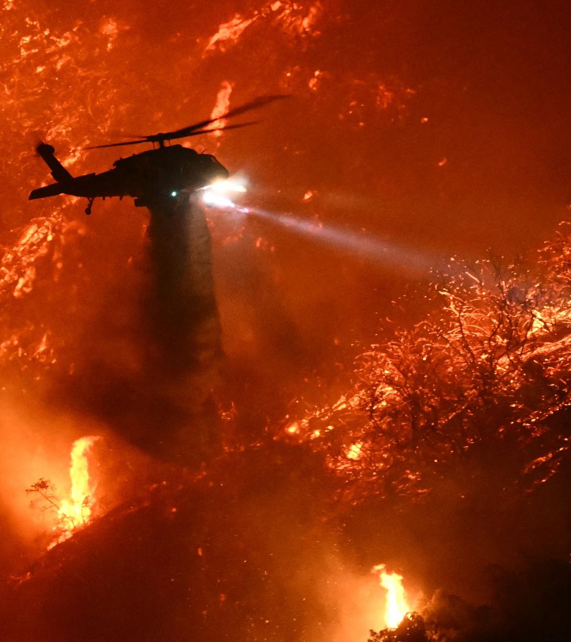 Ein Löschhubschrauber wirft Wasser über dem Palisades-Feuer in Los Angeles ab.