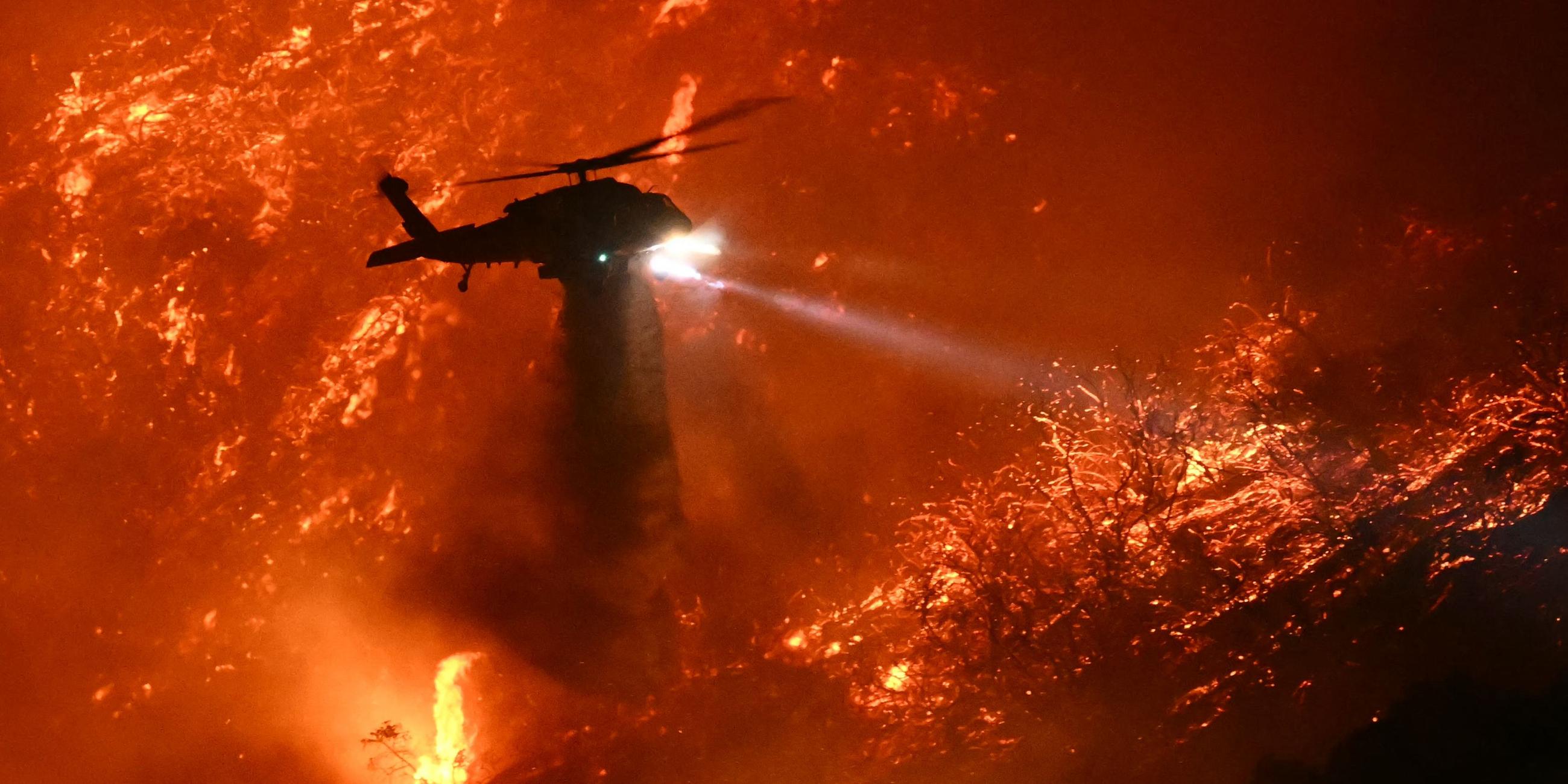 Ein Löschhubschrauber wirft Wasser über dem Palisades-Feuer in Los Angeles ab.