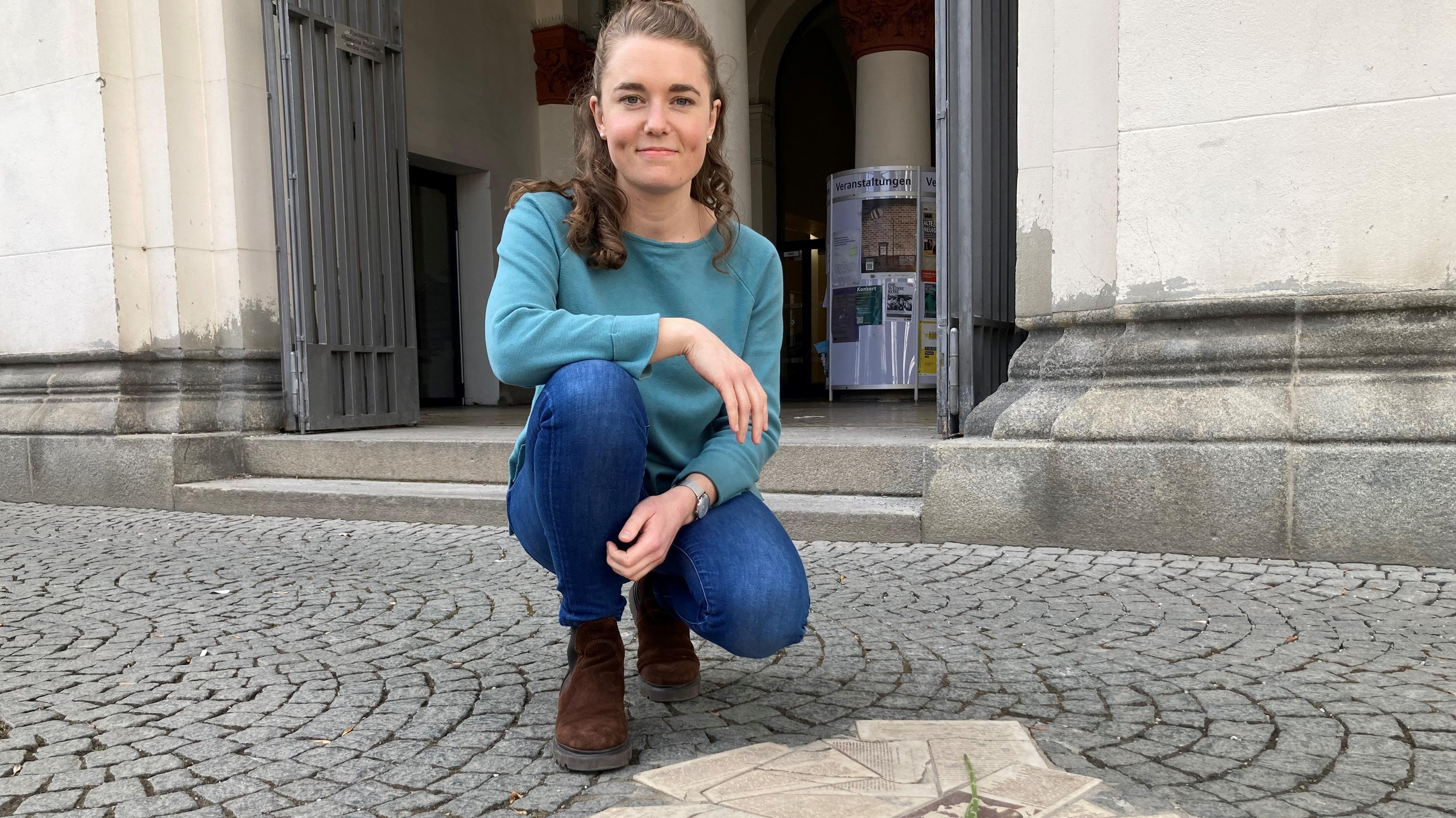 Lotte kniet vor Flugblättern der Weißen Rose