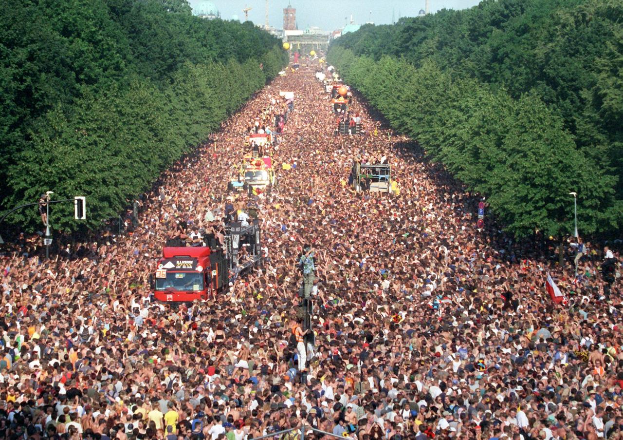 Mit dröhnender, baßvibrierender Techno-Musik ziehen am Samstag (10.07.1999) die Raver über die Straße des 17. Juni im Berliner Tiergarten zwischen dem Brandenburger Tor