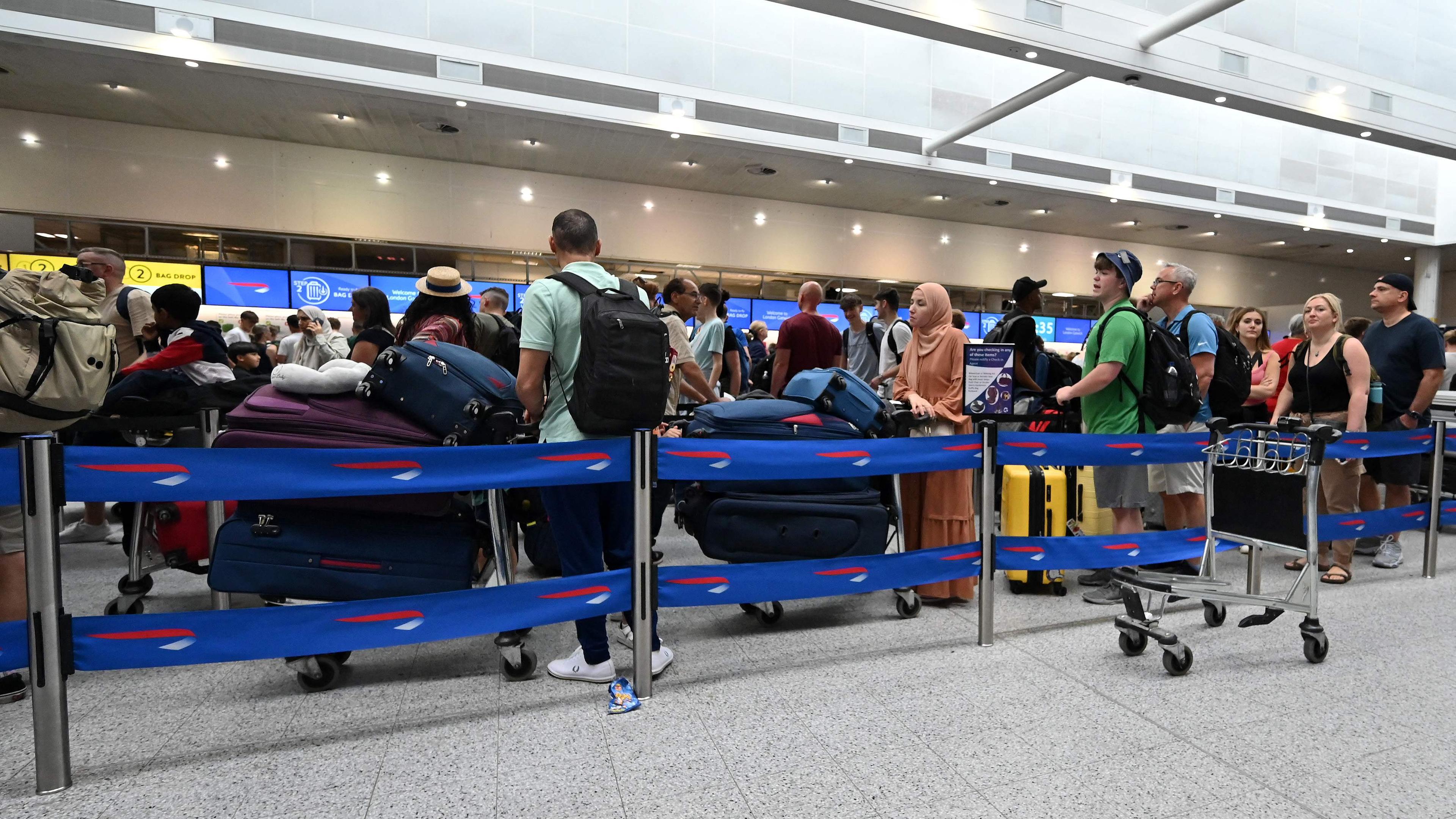 Fluggäste stehen in Schlangen am Londoner Flughafen Gatwick.