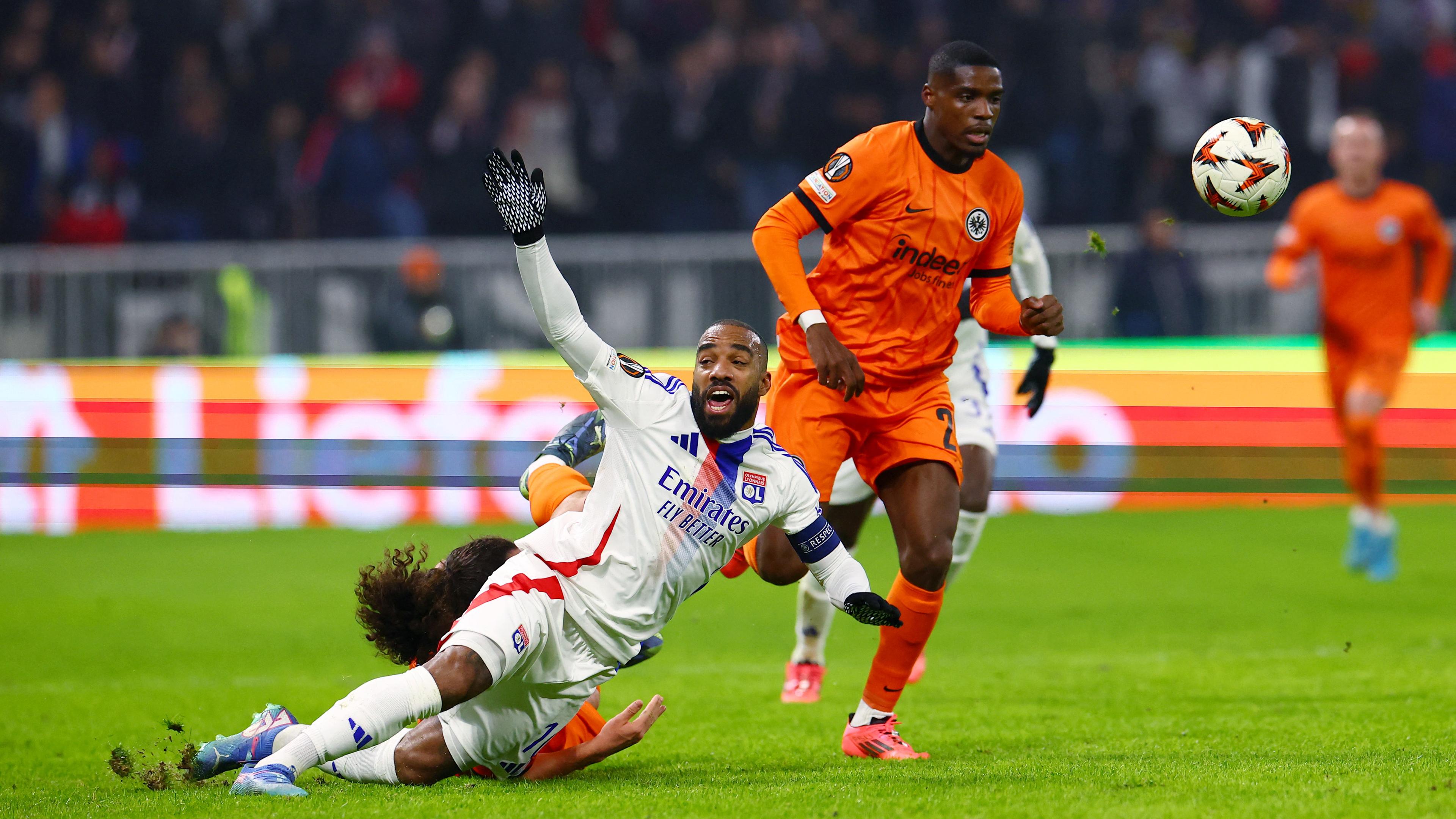 Alexandre Lacazette kämpft mit Eintracht Frankfurts Hugo Ekitike and Niels Nkounkou um den Ball.