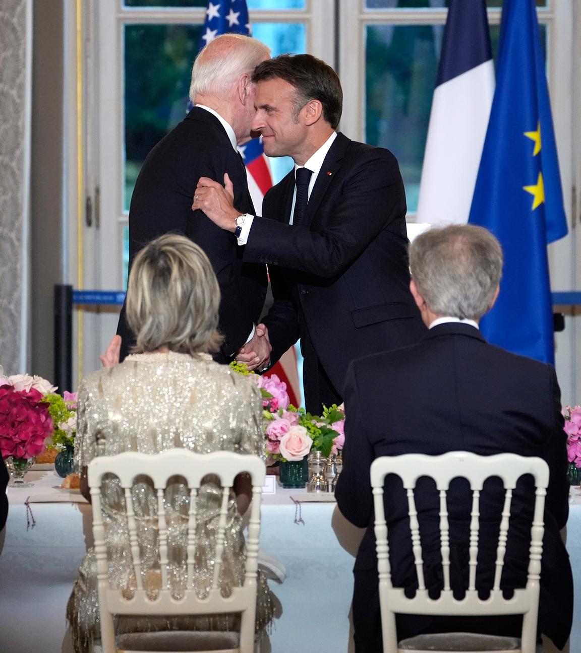 Der französische Präsident Emmanuel Macron (Mitte r) umarmt US-Präsident Joe Biden (Mitte l), während die US-First Lady Jill Biden (r) und Brigitte Macron (l) nach einem Toast während eines Staatsdinners im Elysee-Palast zusehen